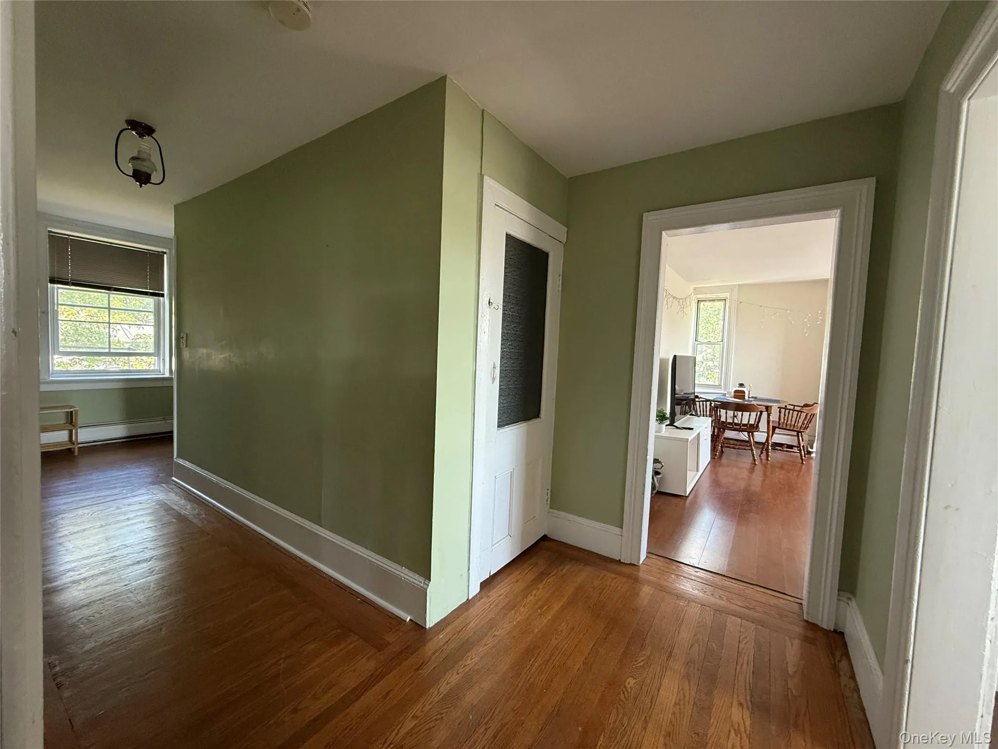 Hallway looking left toward front door and right into Living Room. Door leads to attic, which can be used for storage by tenants. Hallway looking left toward front door and right into Living Room. Door leads to attic, which can be used for storage by tenants.
