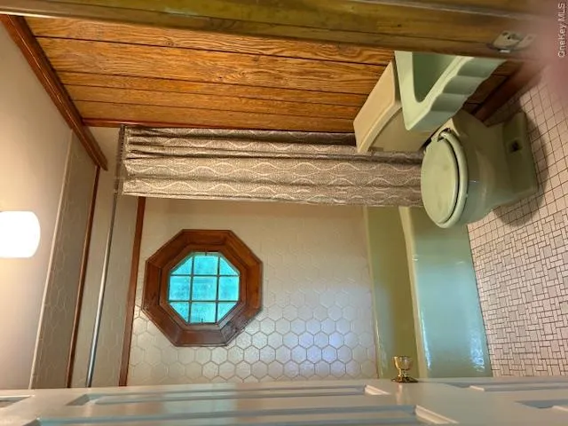 Guest House Bathroom featuring shower / bath combination with curtain and tile patterned flooring Guest House Bathroom featuring shower / bath combination with curtain and tile patterned flooring