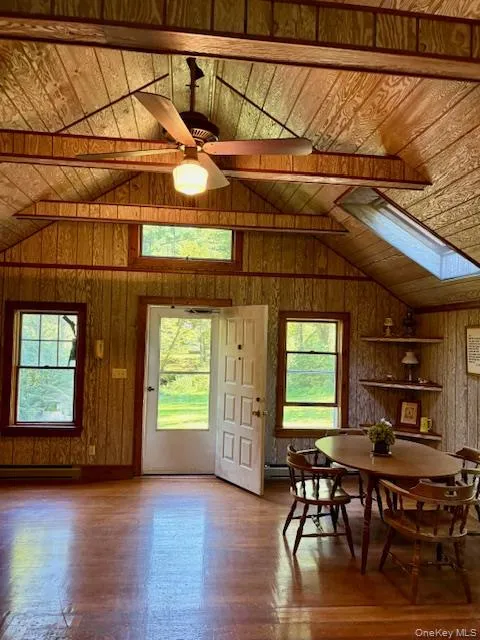 Guest House Dining space with wood walls, vaulted ceiling, wood finished floors, wood ceiling, and a ceiling fan Guest House Dining space with wood walls, vaulted ceiling, wood finished floors, wood ceiling, and a ceiling fan