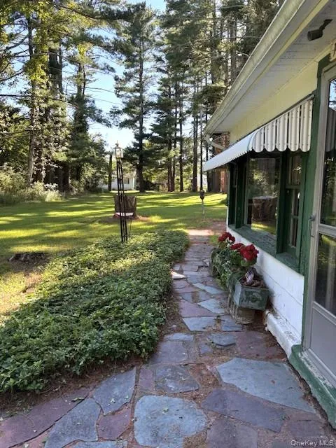Walkway to entrance door facing large lawn Walkway to entrance door facing large lawn