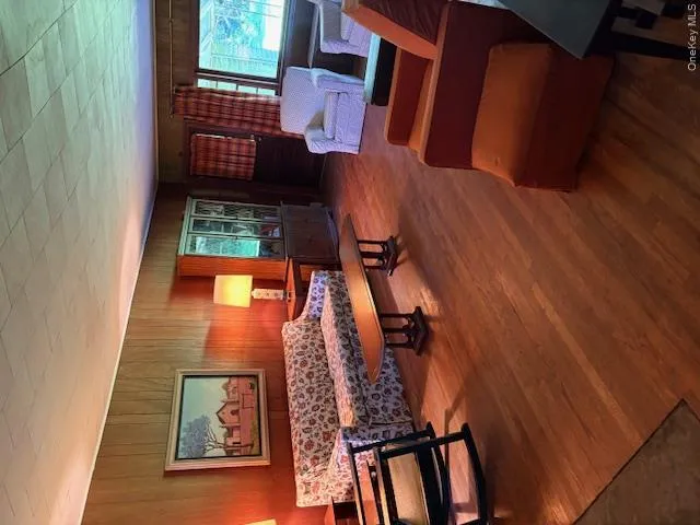 Living area Main House featuring wood walls and wood finished floors Living area Main House featuring wood walls and wood finished floors