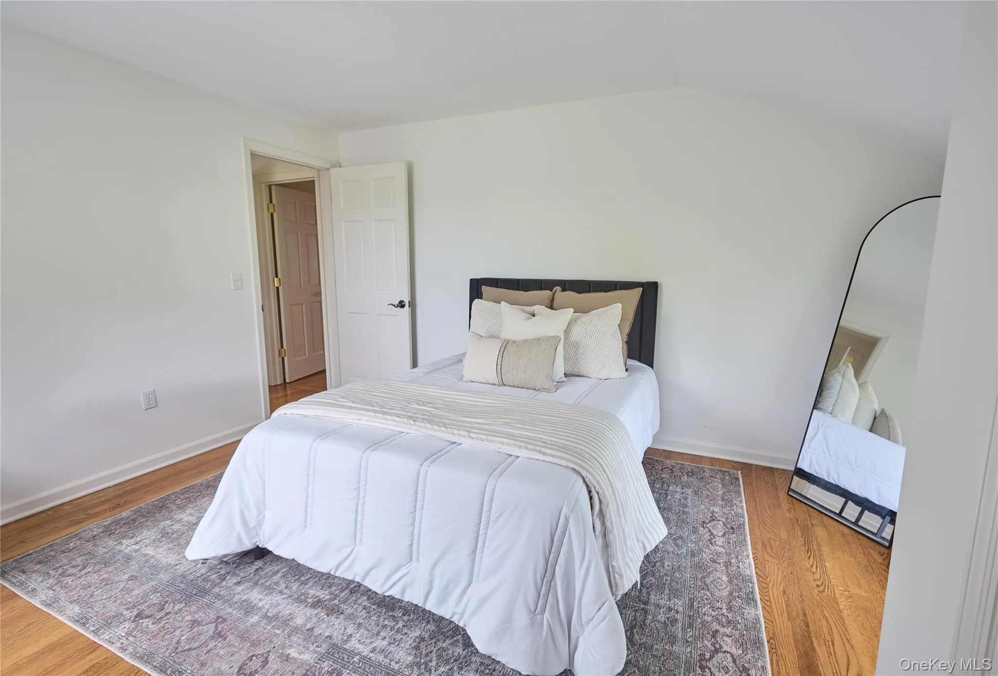 Bedroom featuring wood finished floors and lofted ceiling Bedroom featuring wood finished floors and lofted ceiling