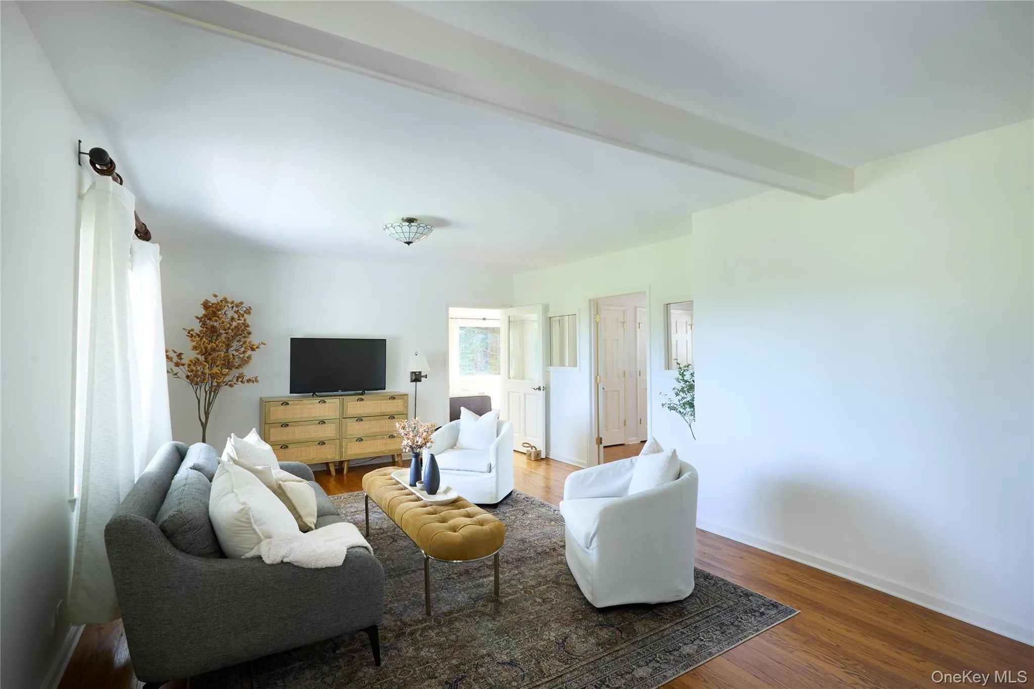 Living area featuring beamed ceiling and wood finished floors Living area featuring beamed ceiling and wood finished floors