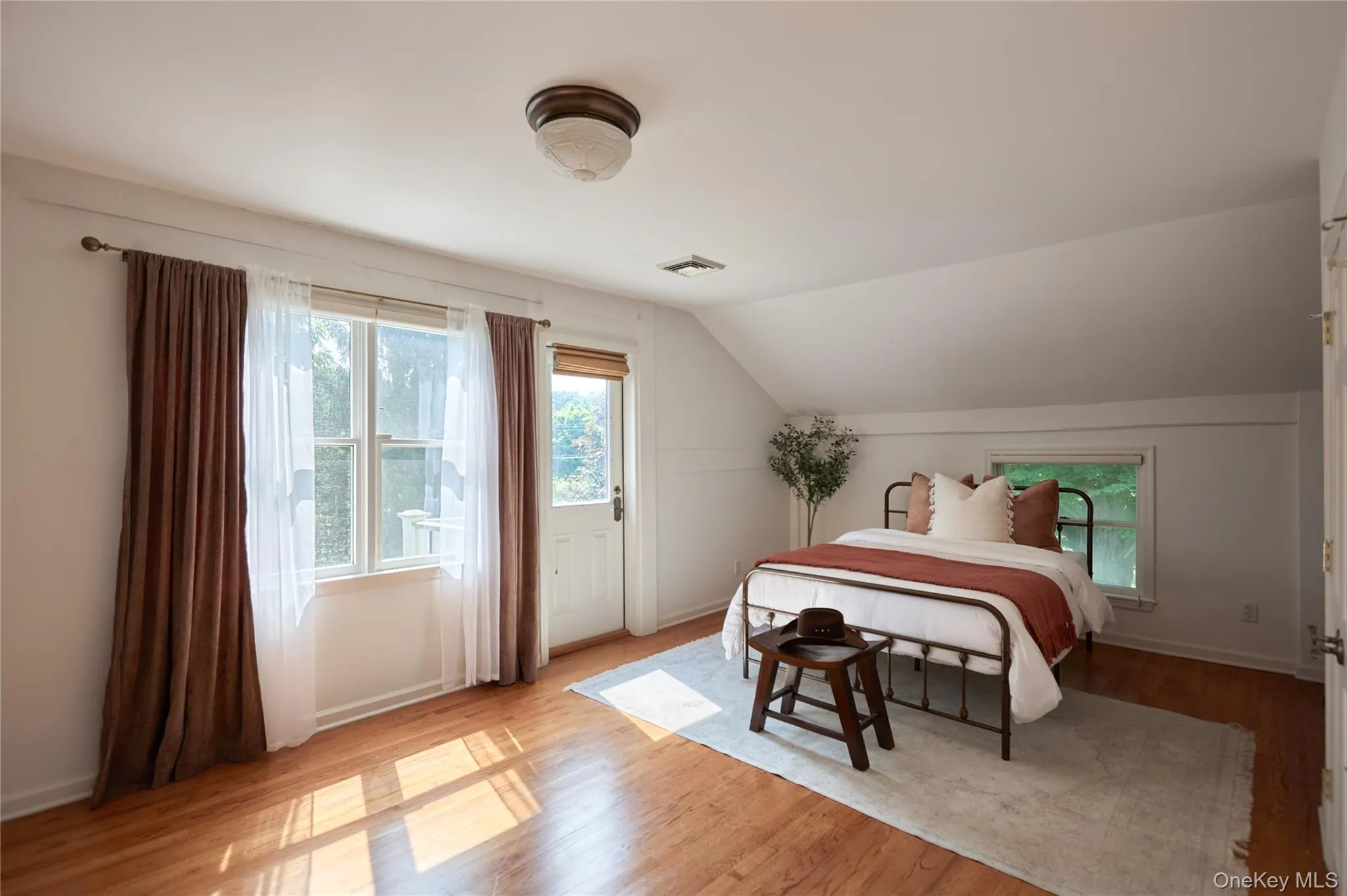 Bedroom with light wood-type flooring and lofted ceiling Bedroom with light wood-type flooring and lofted ceiling