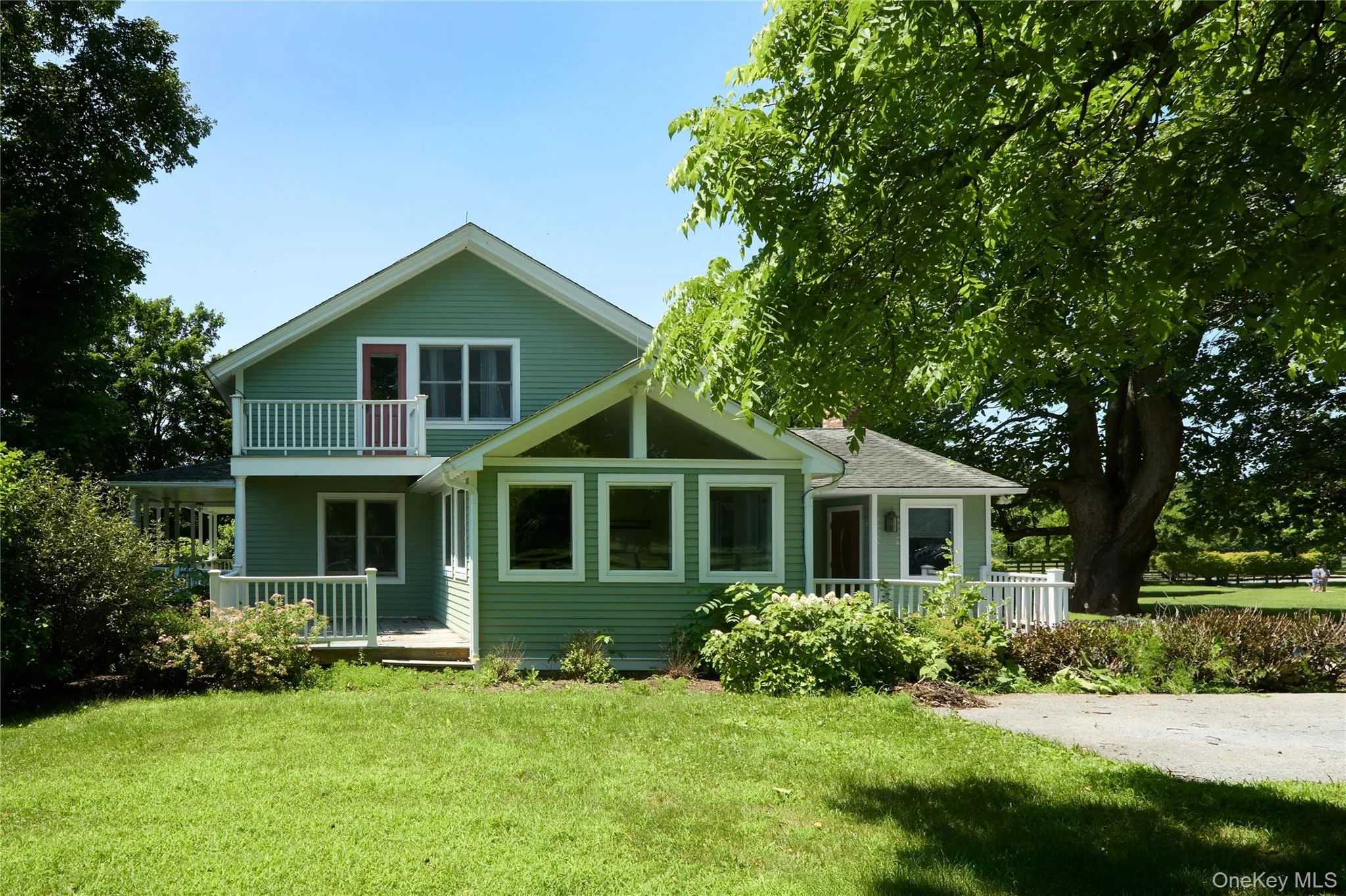 Rear view of house featuring a porch and a lawn Rear view of house featuring a porch and a lawn