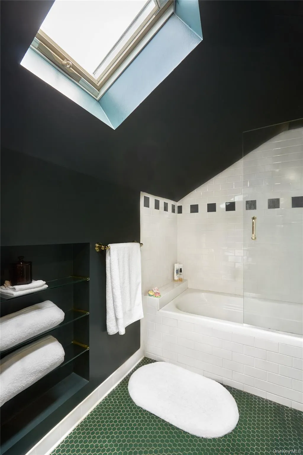 Bathroom featuring vaulted ceiling, a garden tub, and a skylight Bathroom featuring vaulted ceiling, a garden tub, and a skylight