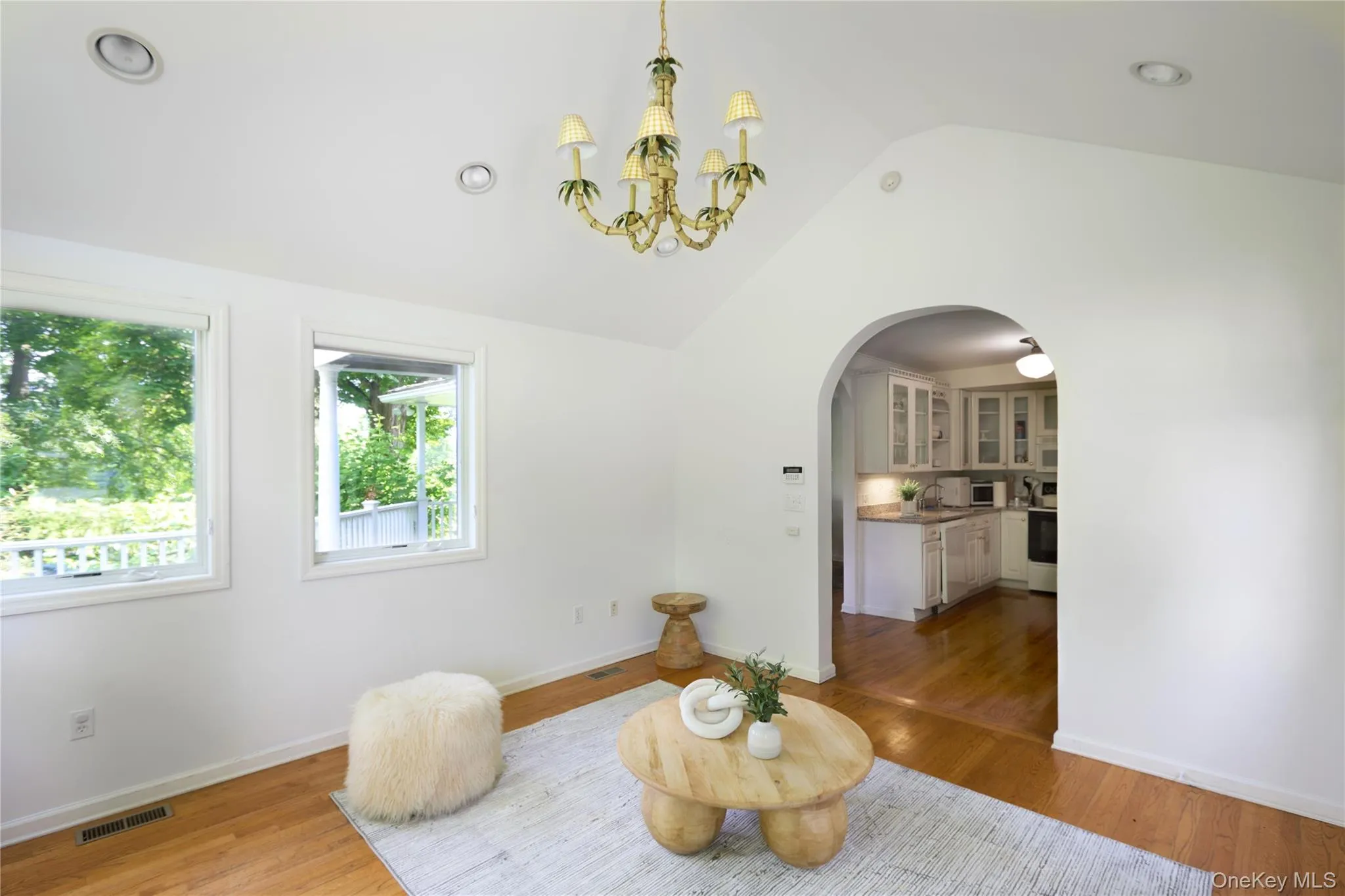 Dining room with vaulted ceiling, light wood-style flooring, a chandelier, arched walkways, and recessed lighting Dining room with vaulted ceiling, light wood-style flooring, a chandelier, arched walkways, and recessed lighting