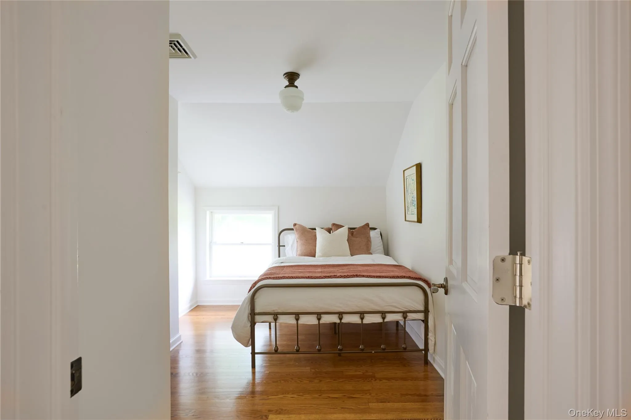 Bedroom with vaulted ceiling and light wood finished floors Bedroom with vaulted ceiling and light wood finished floors