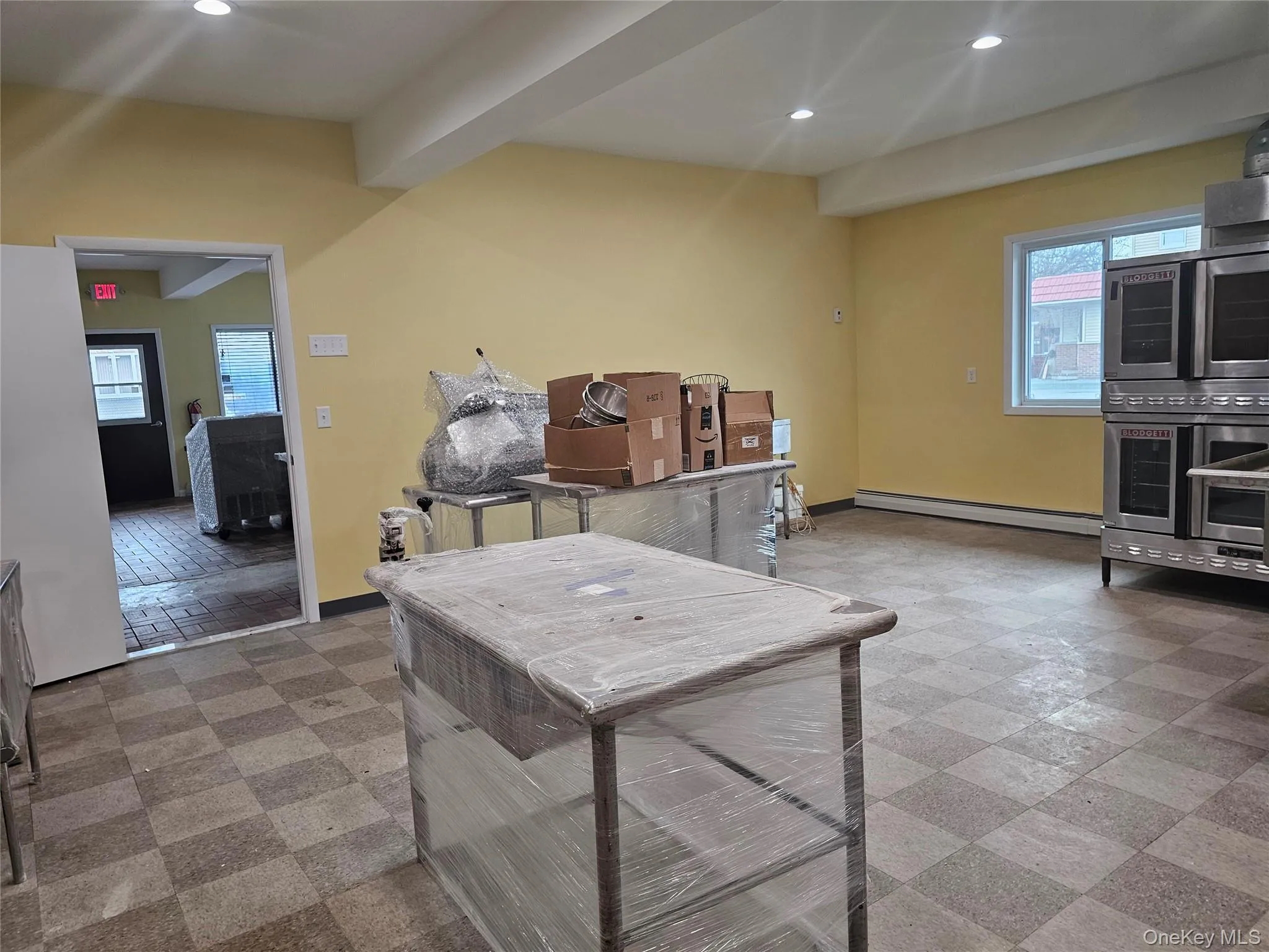 Kitchen featuring plenty of natural light, beamed ceiling, recessed lighting, light flooring, and a baseboard radiator Kitchen featuring plenty of natural light, beamed ceiling, recessed lighting, light flooring, and a baseboard radiator