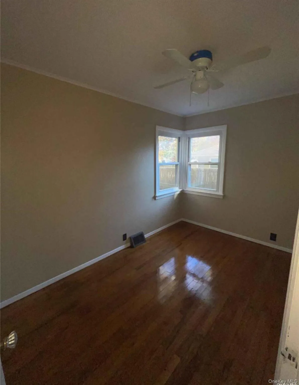 Spare room with dark wood-style floors and ceiling fan Spare room with dark wood-style floors and ceiling fan