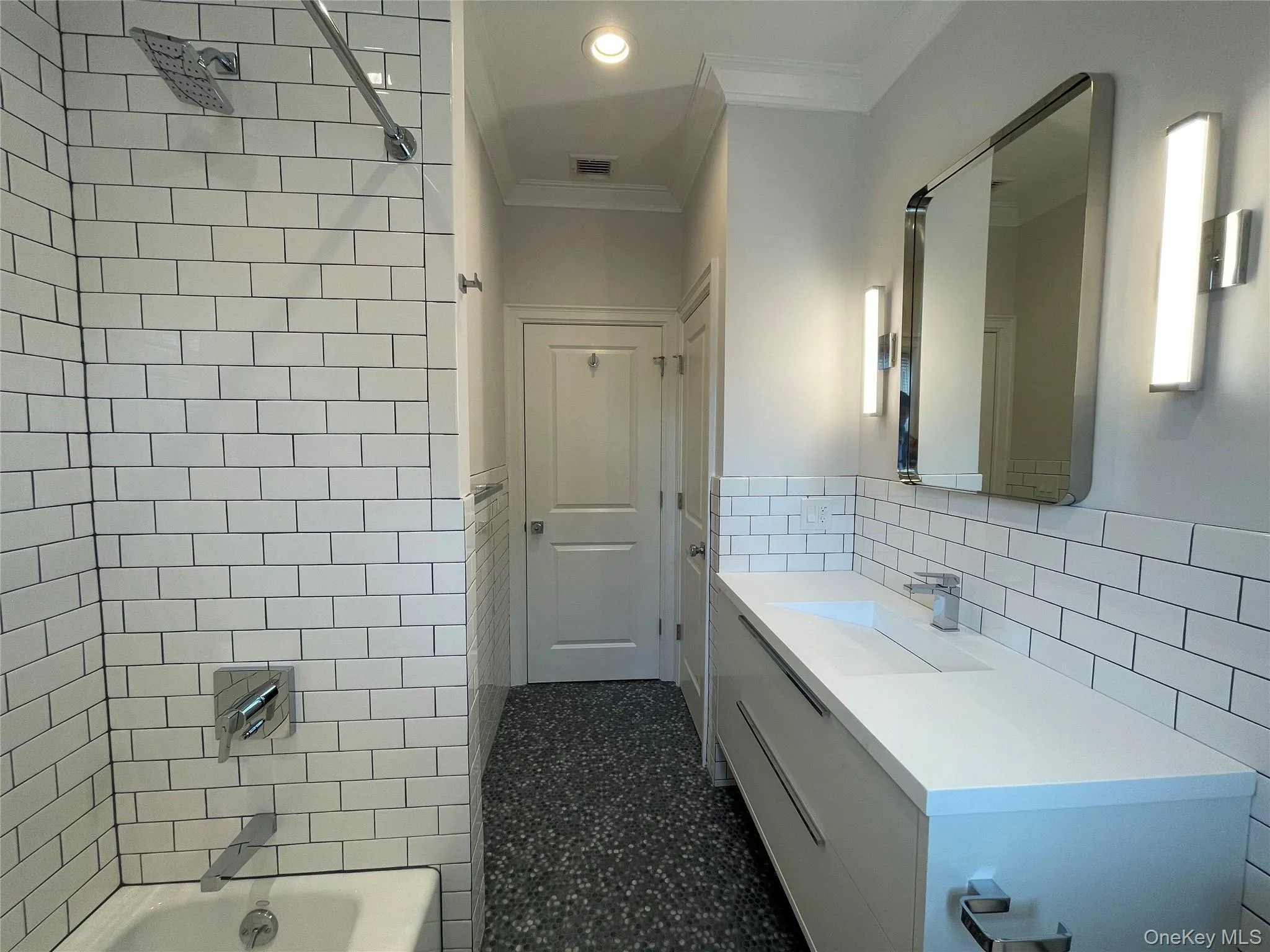 Hall bath with ornamental molding, vanity, shower / tub combination, recessed lighting, and tile walls Hall bath with ornamental molding, vanity, shower / tub combination, recessed lighting, and tile walls