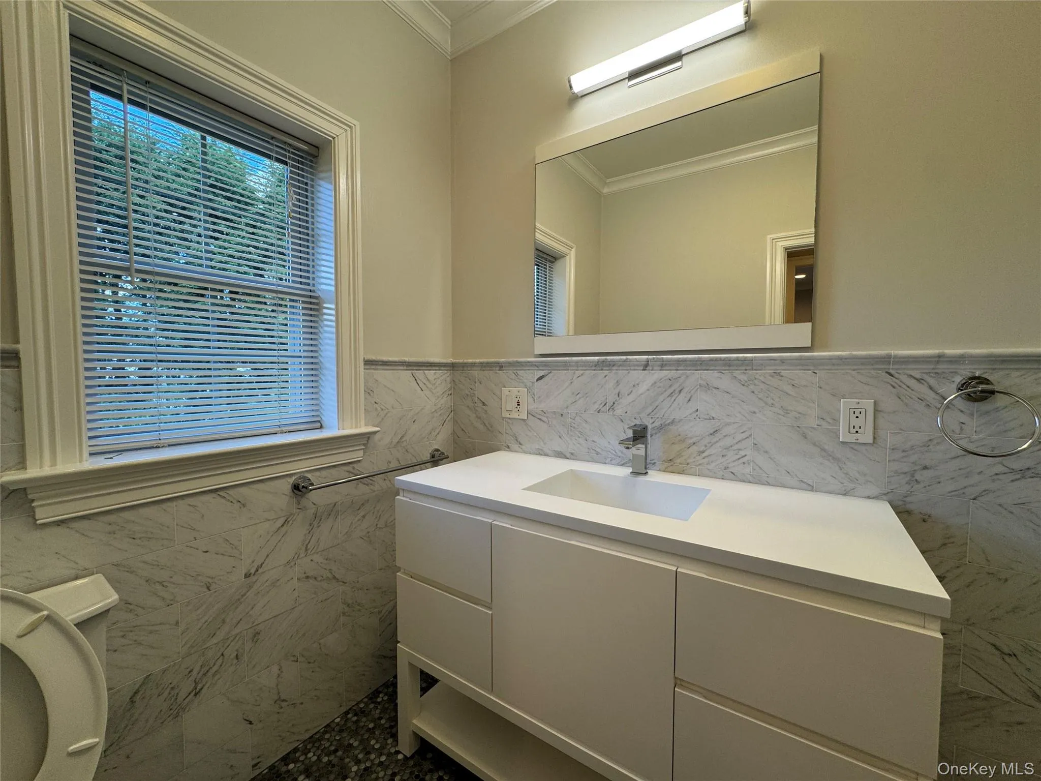 Bathroom featuring tile walls, vanity, crown molding, and a wainscoted wall Bathroom featuring tile walls, vanity, crown molding, and a wainscoted wall