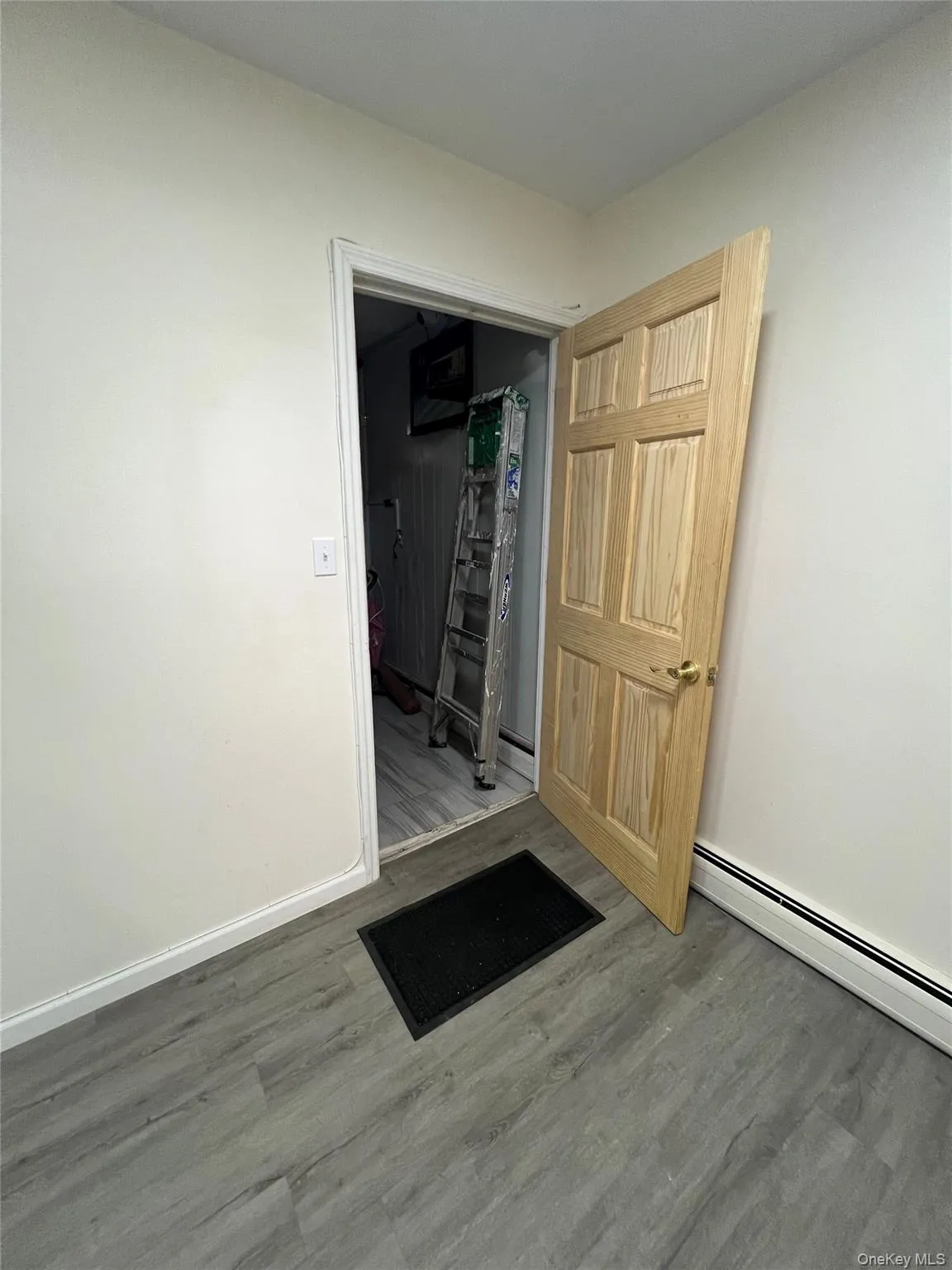 Empty room featuring a baseboard heating unit and wood finished floors Empty room featuring a baseboard heating unit and wood finished floors