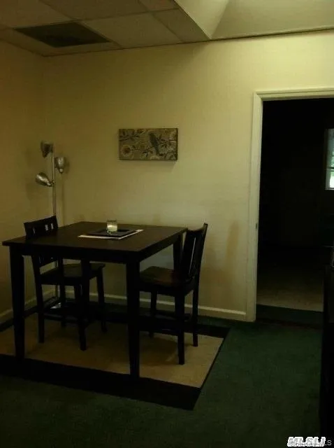 Dining space featuring a paneled ceiling and dark colored carpet Dining space featuring a paneled ceiling and dark colored carpet