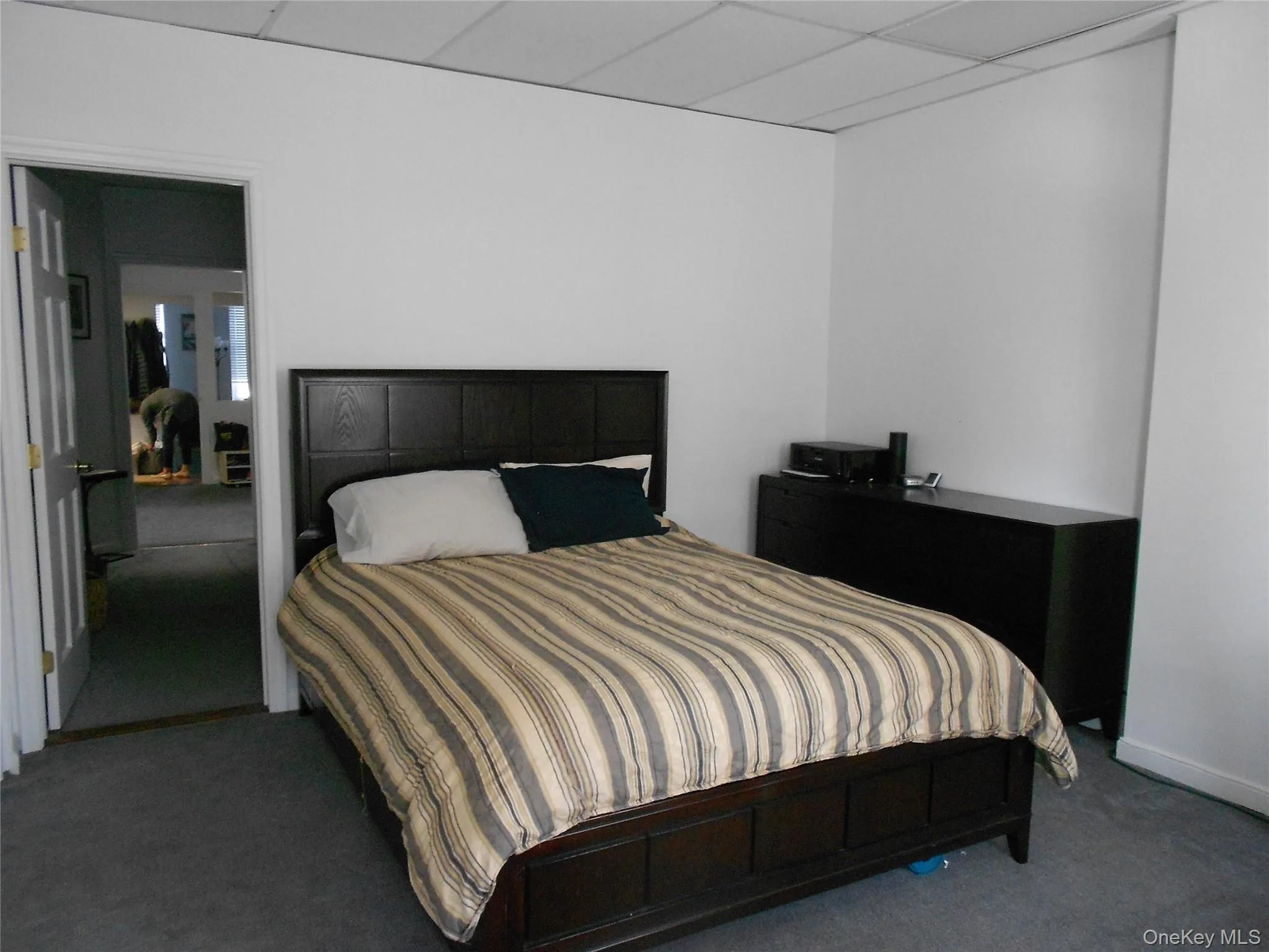 Bedroom with a paneled ceiling and carpet flooring Bedroom with a paneled ceiling and carpet flooring