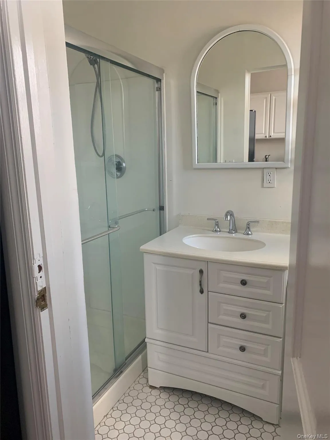 Full bath with a stall shower, vanity, and light tile patterned floors Full bath with a stall shower, vanity, and light tile patterned floors