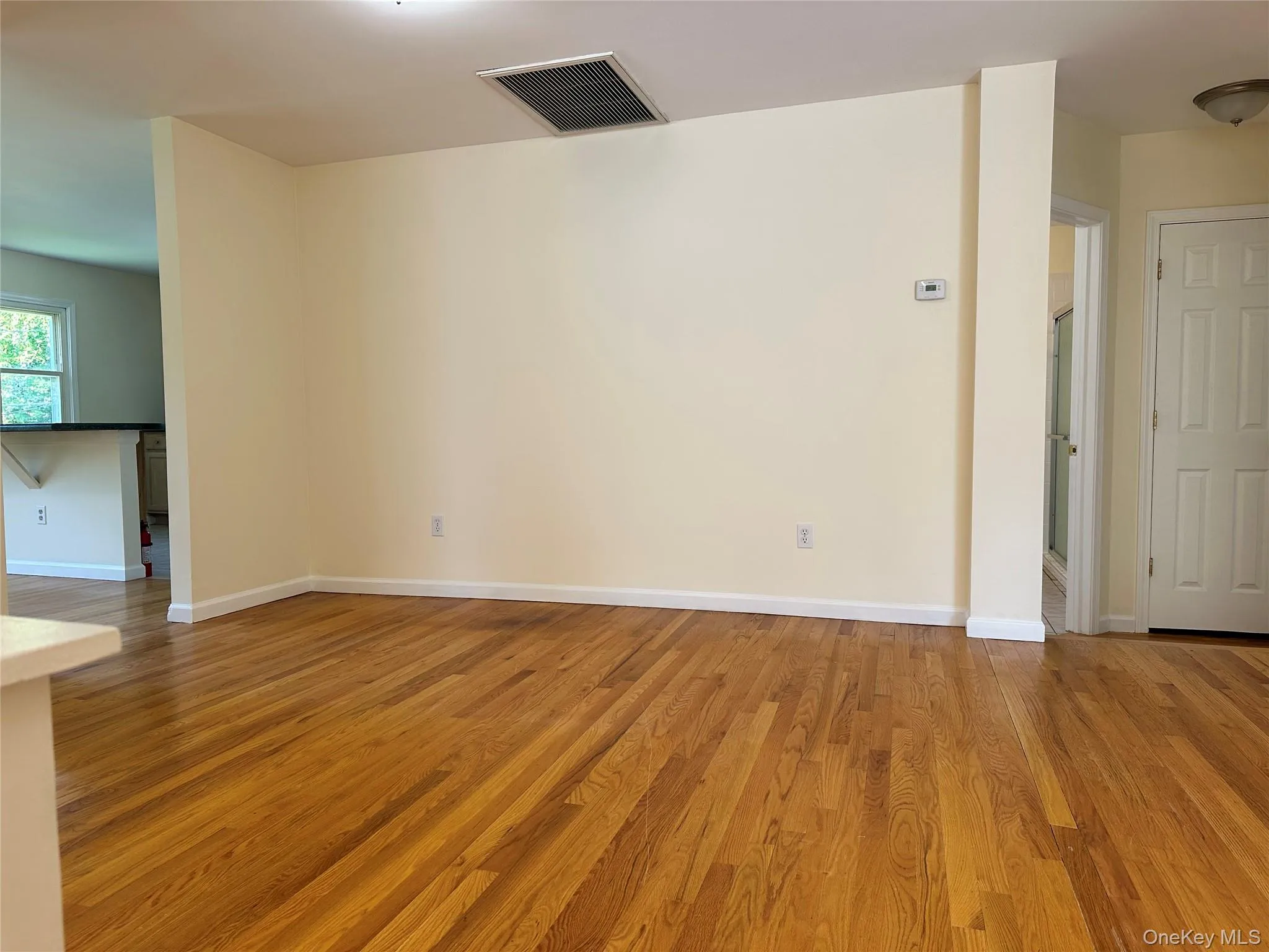 Empty room with light wood finished floors and baseboards Empty room with light wood finished floors and baseboards