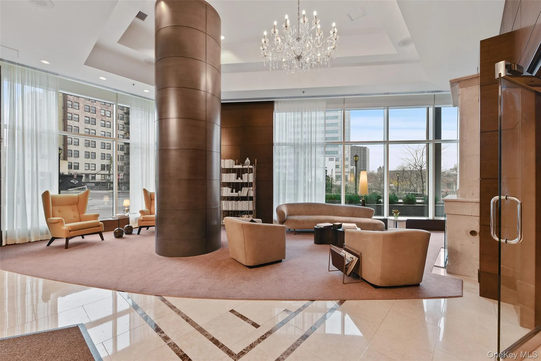 Common area with recessed lighting, a towering ceiling, floor to ceiling windows, and a view of city Common area with recessed lighting, a towering ceiling, floor to ceiling windows, and a view of city