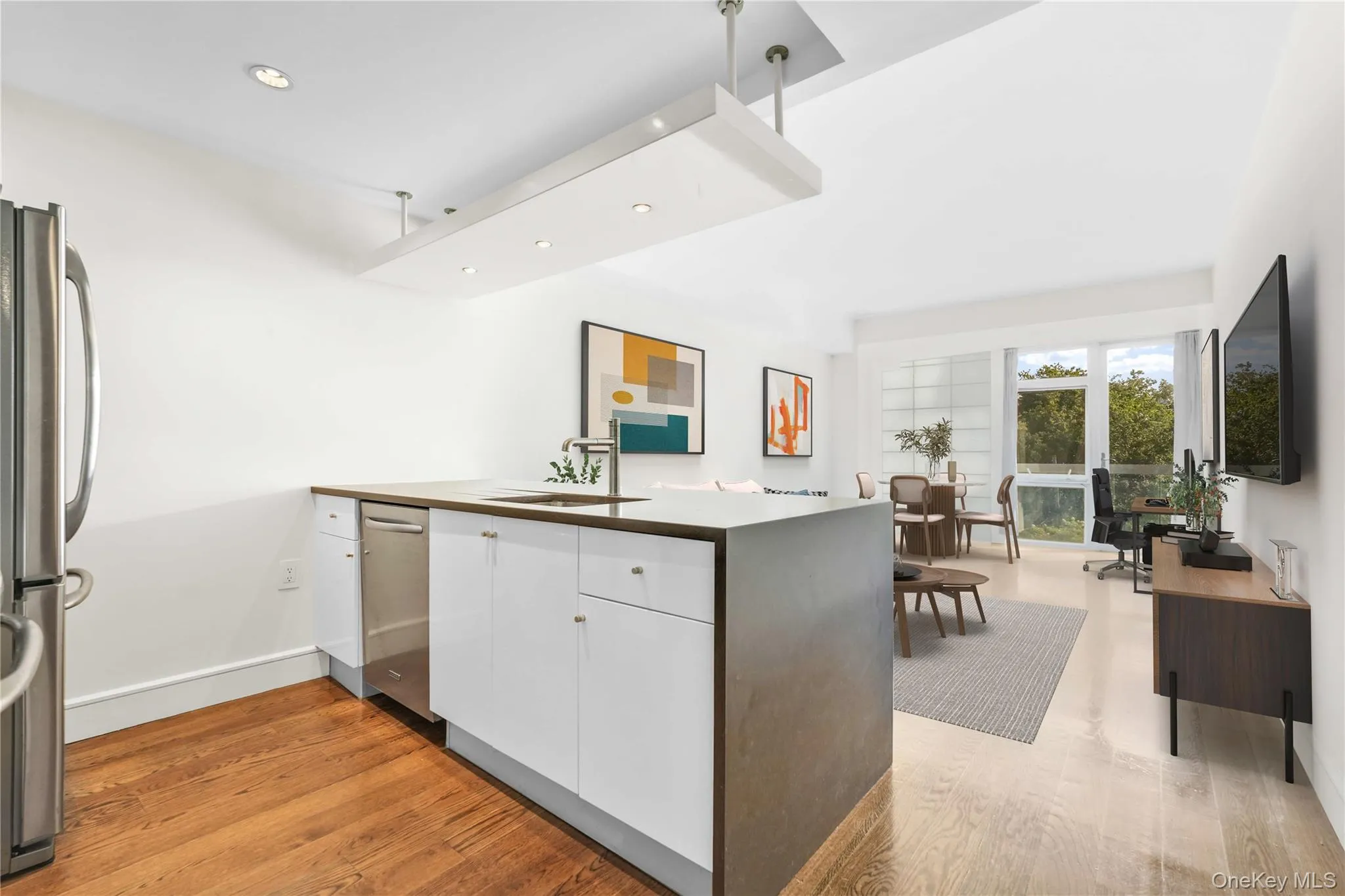 Kitchen with white cabinets, recessed lighting, light wood-type flooring, a peninsula, and stainless steel appliances Kitchen with white cabinets, recessed lighting, light wood-type flooring, a peninsula, and stainless steel appliances