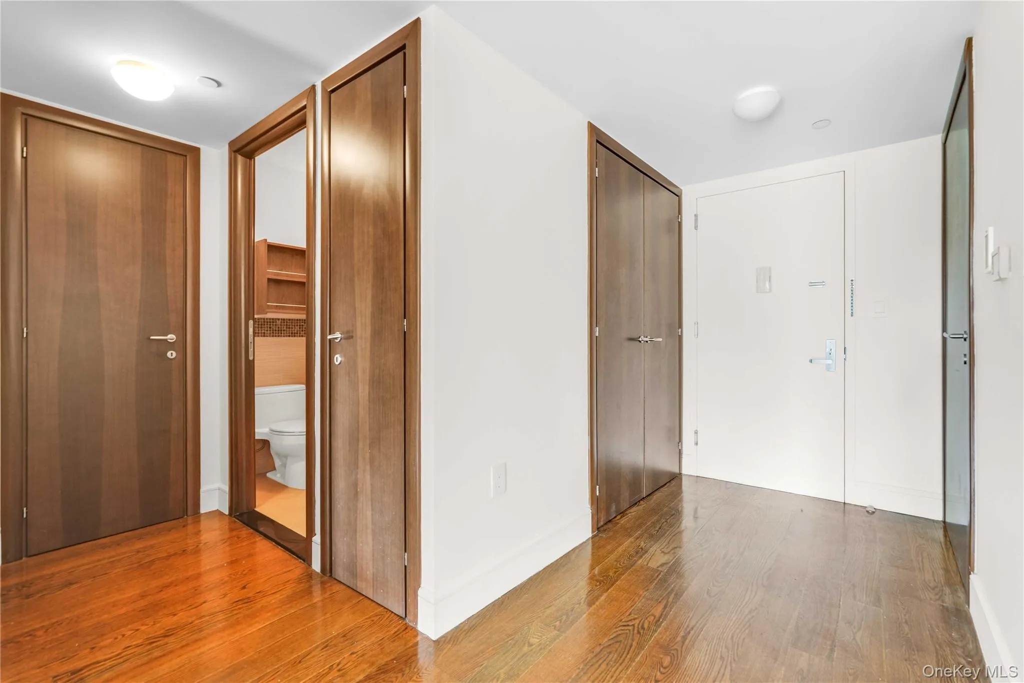 Corridor featuring wood finished floors Corridor featuring wood finished floors