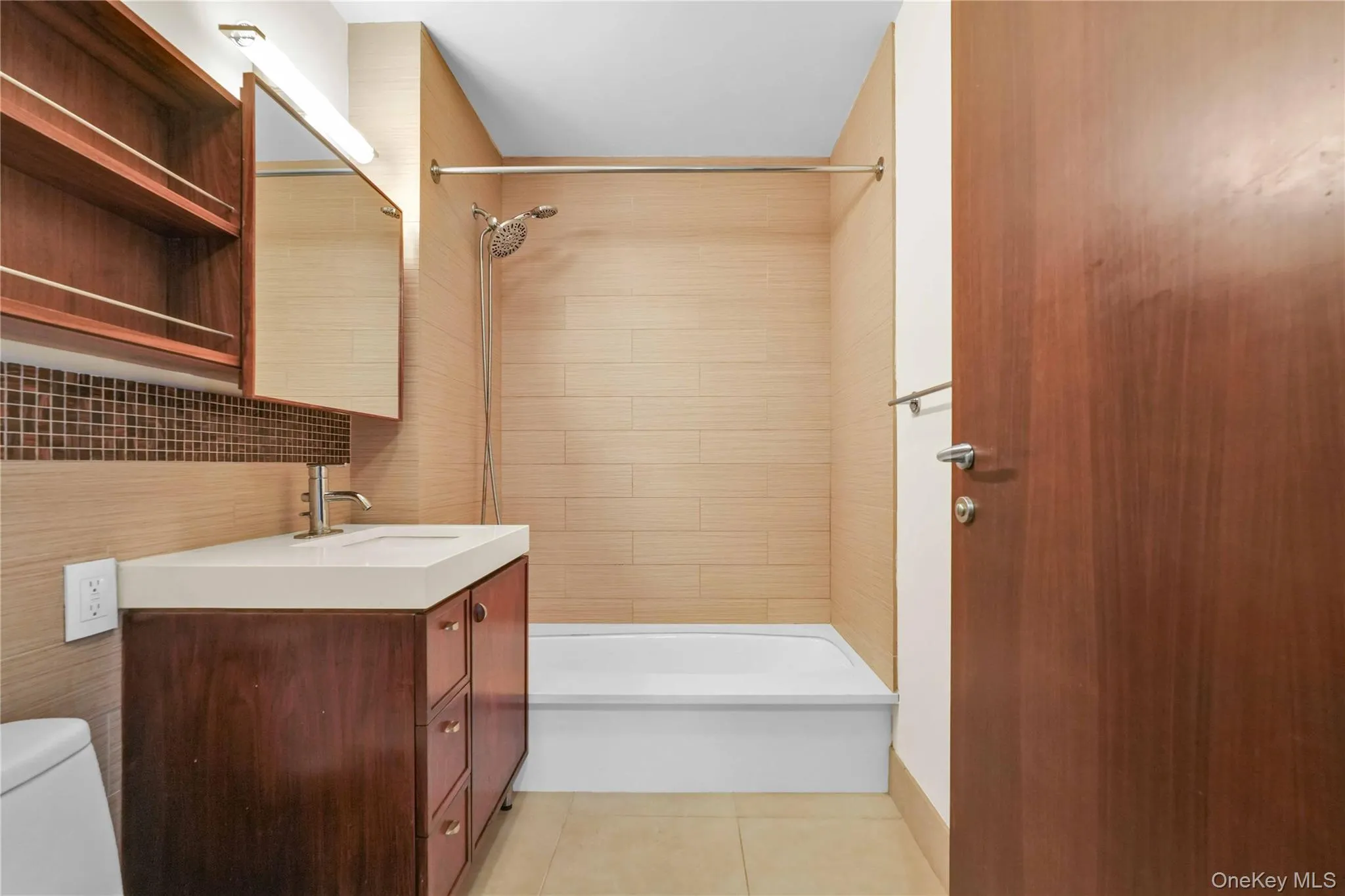Full bath with light tile patterned floors, vanity, washtub / shower combination, and decorative backsplash Full bath with light tile patterned floors, vanity, washtub / shower combination, and decorative backsplash