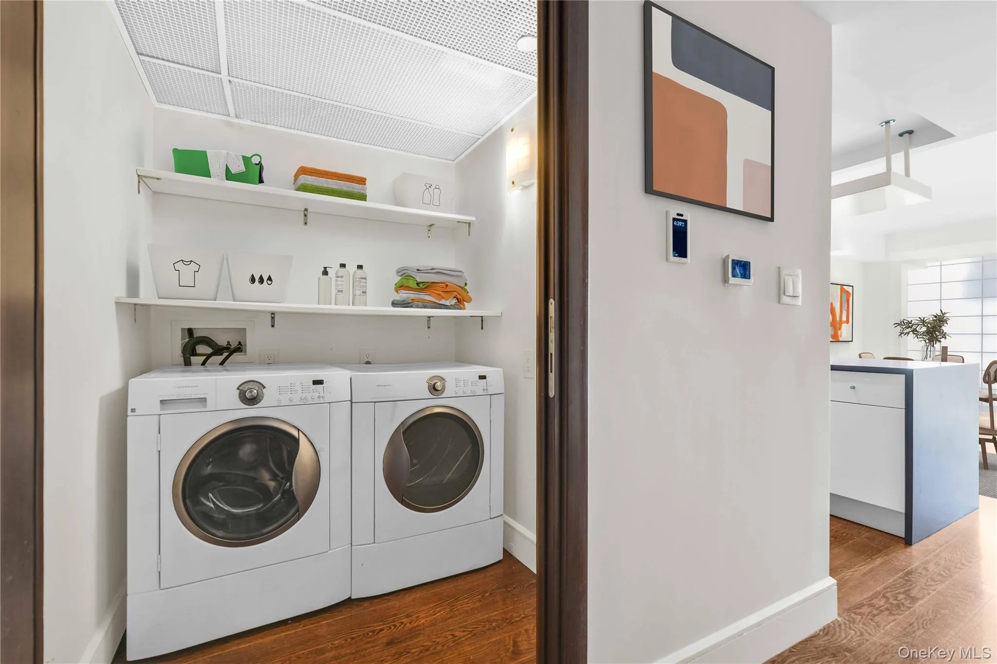 Laundry room featuring dark wood finished floors and washer and clothes dryer Laundry room featuring dark wood finished floors and washer and clothes dryer