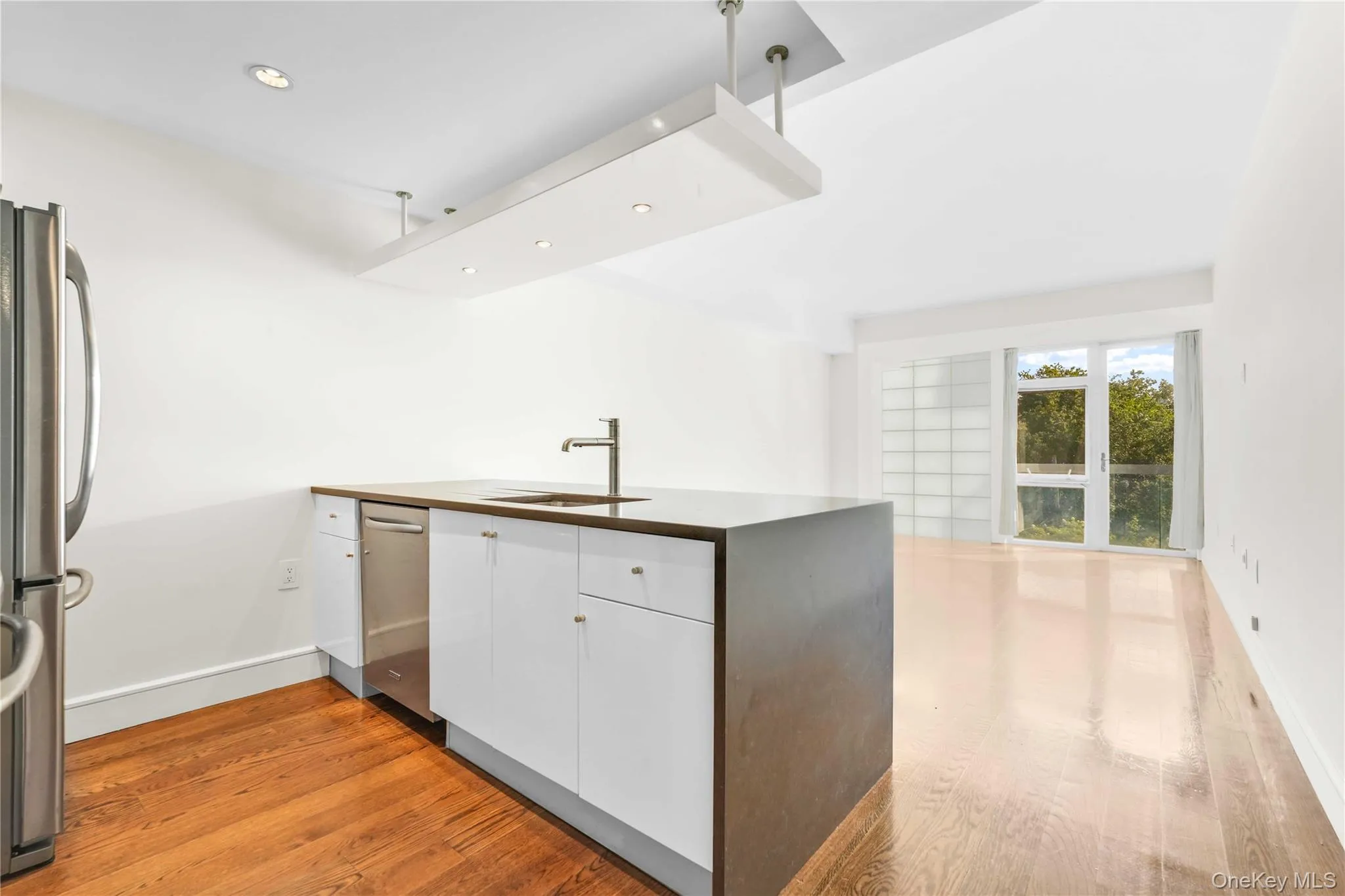 Kitchen featuring white cabinets, light wood-type flooring, recessed lighting, appliances with stainless steel finishes, and modern cabinets Kitchen featuring white cabinets, light wood-type flooring, recessed lighting, appliances with stainless steel finishes, and modern cabinets