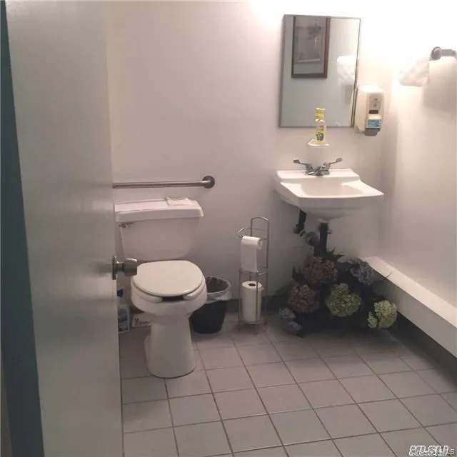 Bathroom featuring light tile patterned floors and toilet Bathroom featuring light tile patterned floors and toilet