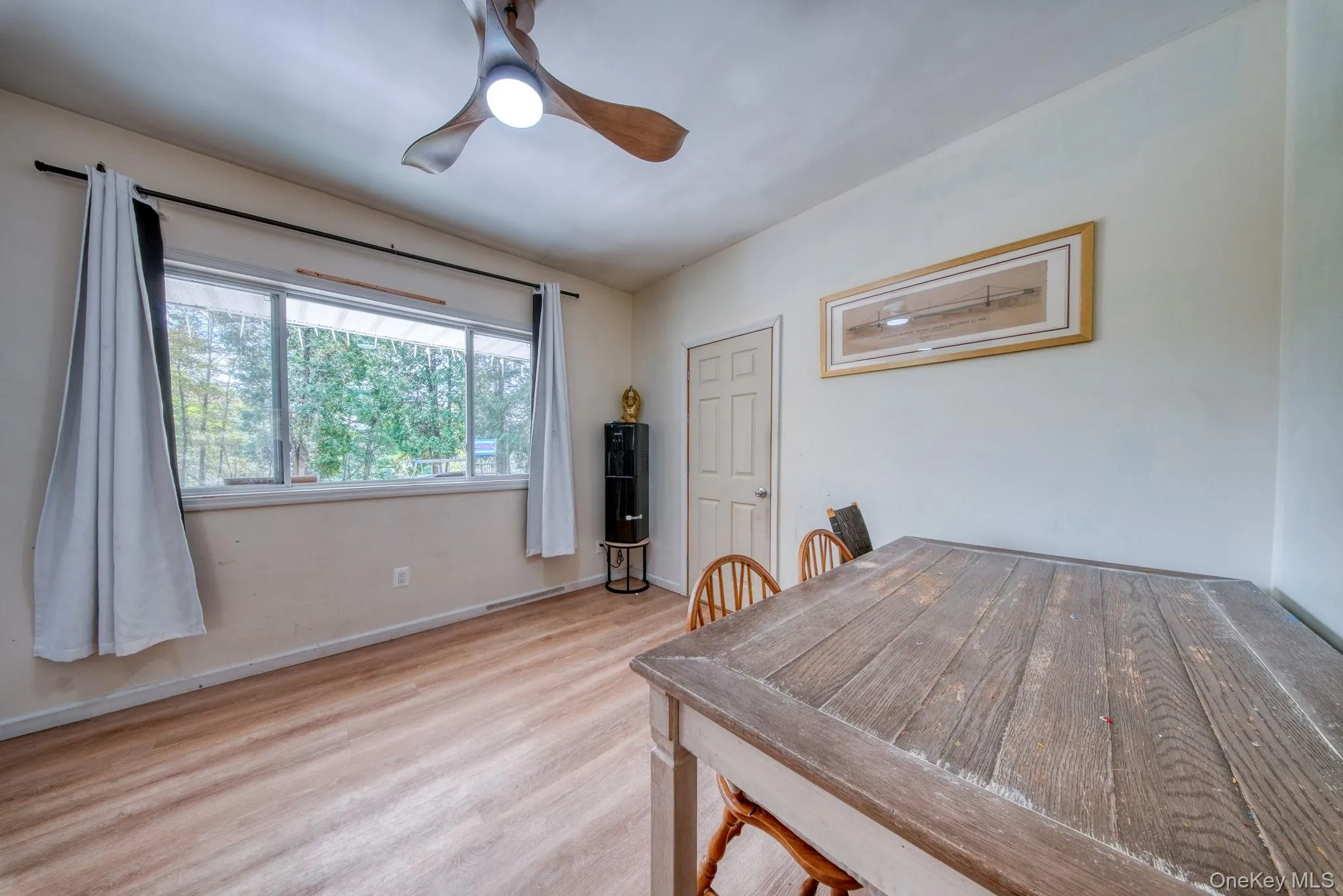 Dining space featuring light wood-style floors and a ceiling fan Dining space featuring light wood-style floors and a ceiling fan