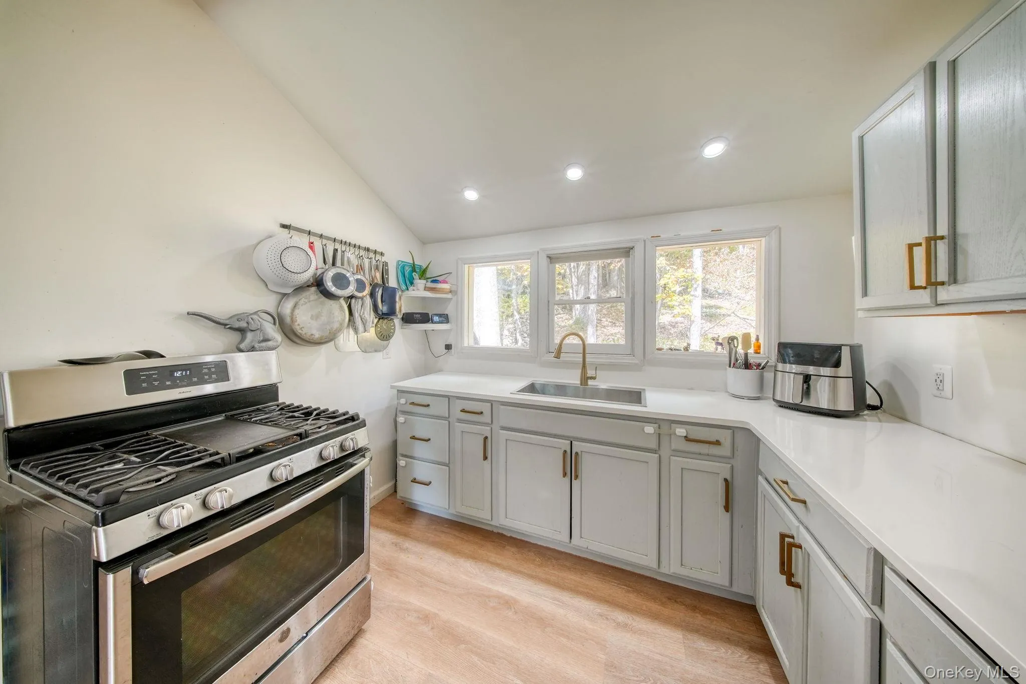 Kitchen featuring gas range, vaulted ceiling, light wood-style floors, recessed lighting, and open shelves Kitchen featuring gas range, vaulted ceiling, light wood-style floors, recessed lighting, and open shelves