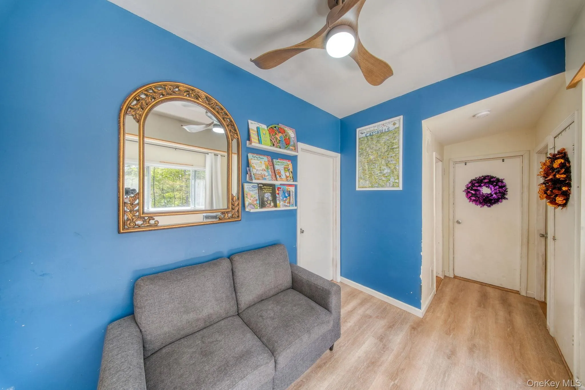 Living area featuring wood finished floors and ceiling fan Living area featuring wood finished floors and ceiling fan