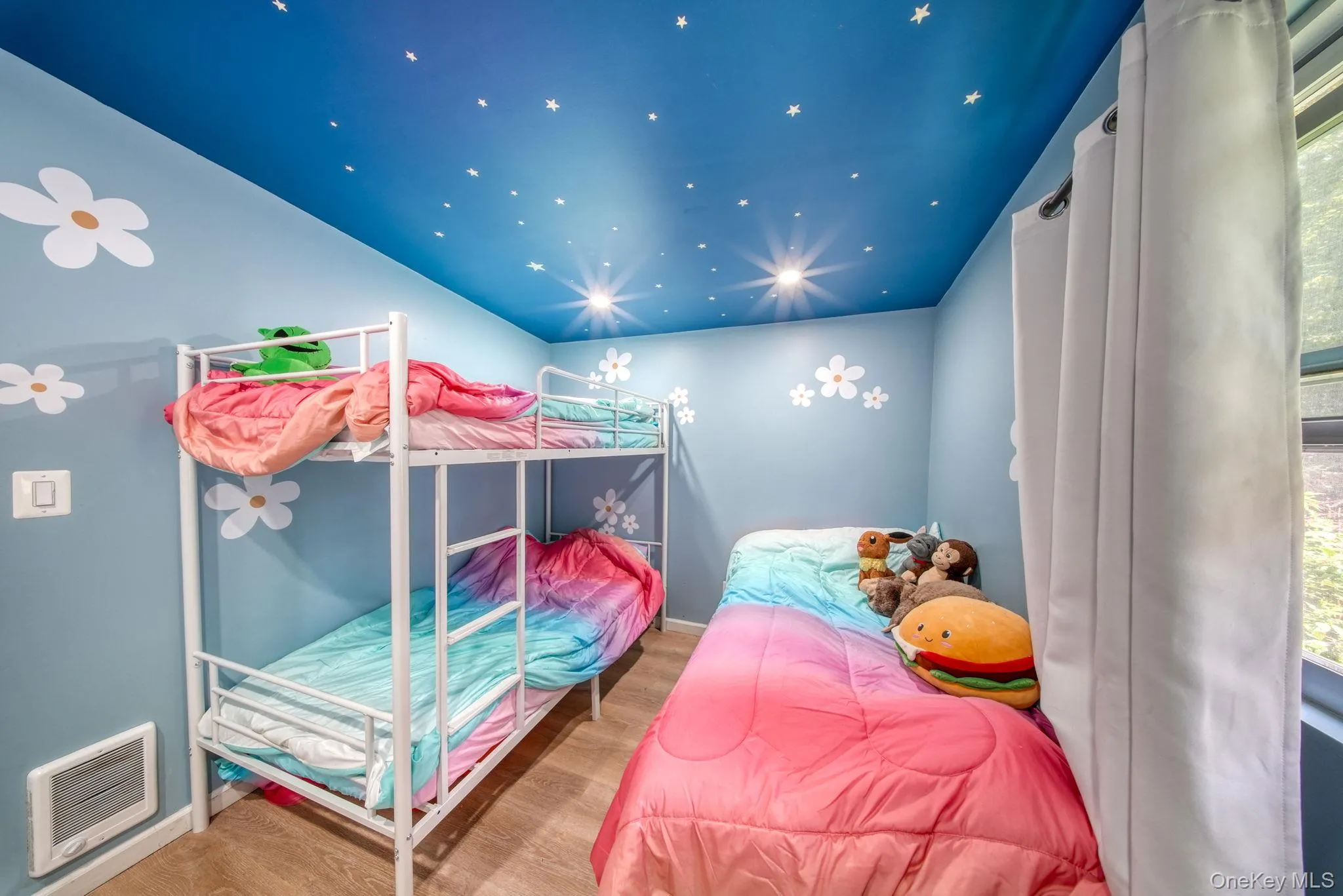 Bedroom featuring wood finished floors and heating unit Bedroom featuring wood finished floors and heating unit