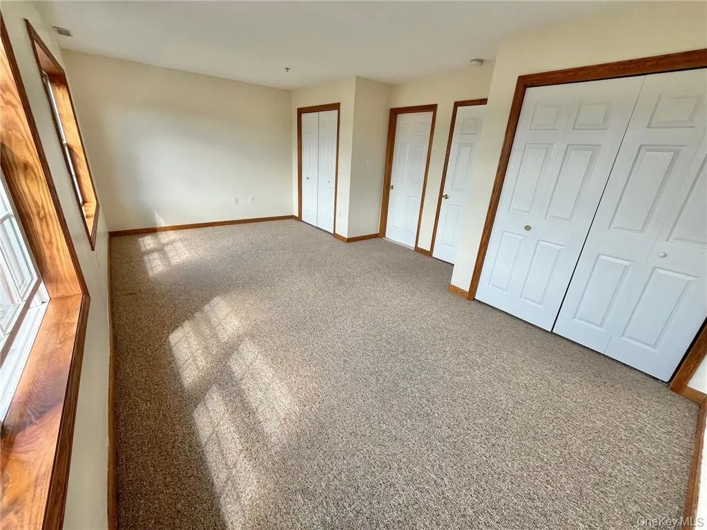 Unfurnished bedroom featuring two closets and carpet Unfurnished bedroom featuring two closets and carpet