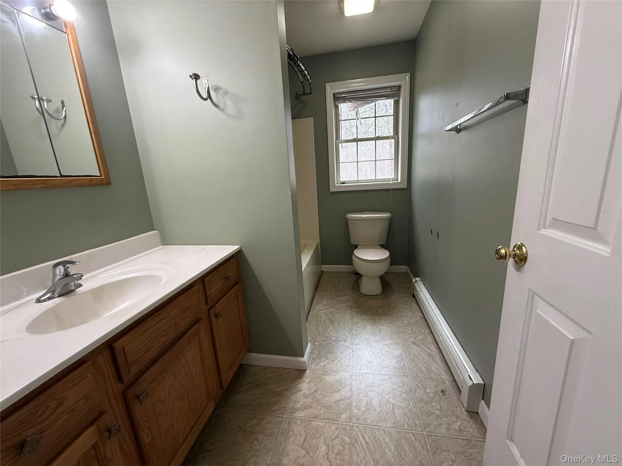 Bathroom featuring a baseboard radiator, vanity, and shower / bath combination Bathroom featuring a baseboard radiator, vanity, and shower / bath combination