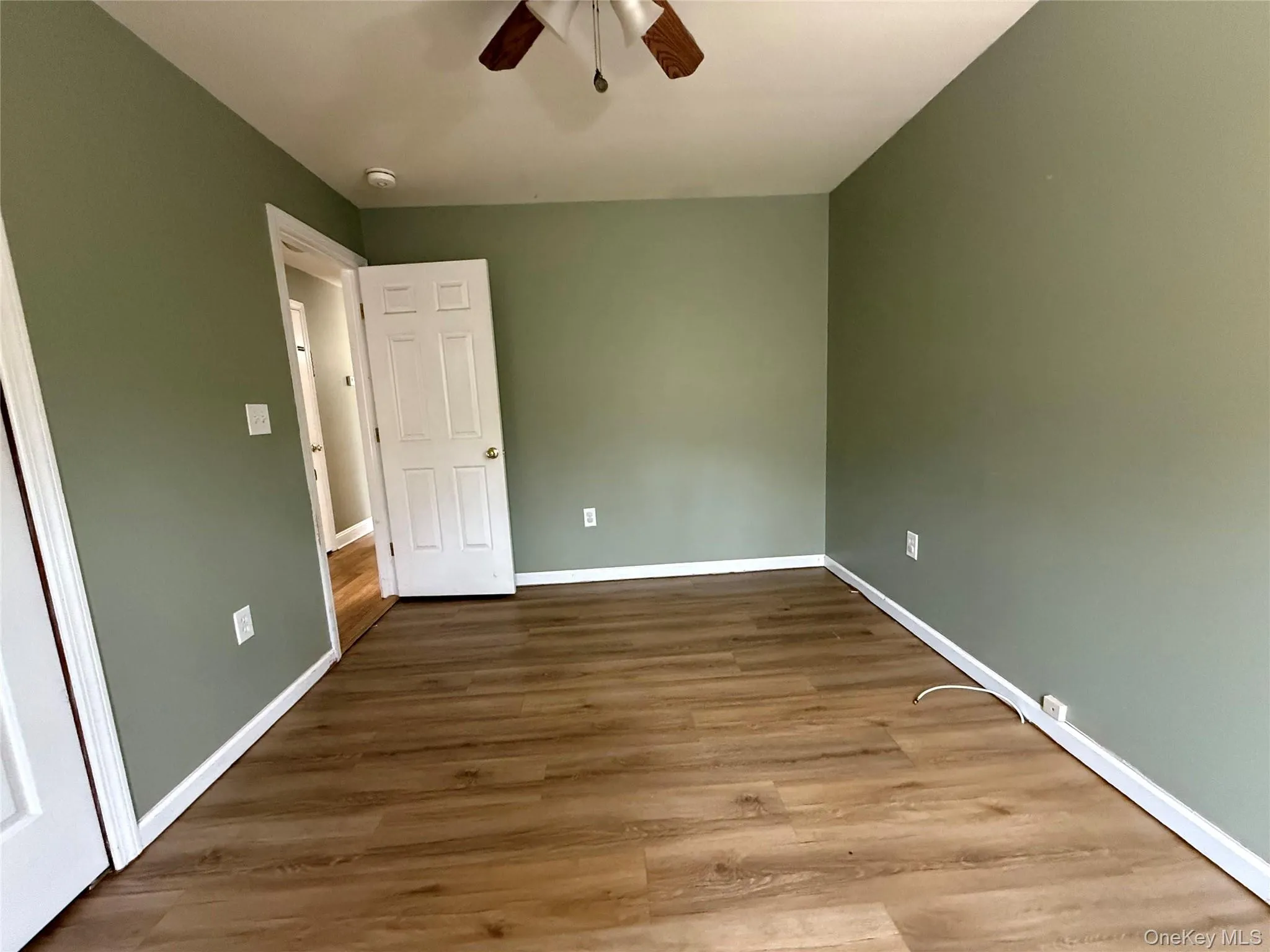 Unfurnished bedroom with wood finished floors and a ceiling fan Unfurnished bedroom with wood finished floors and a ceiling fan