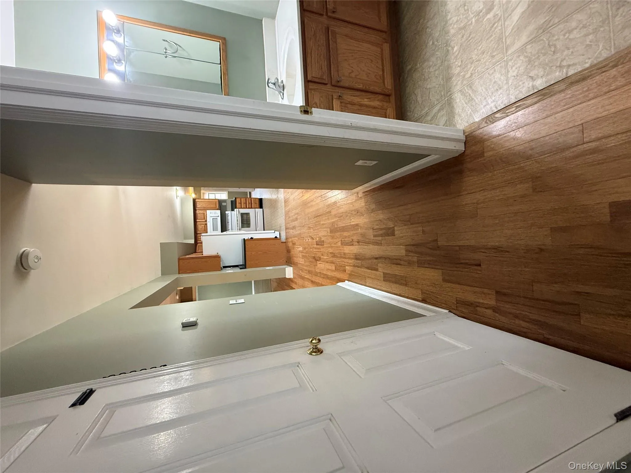 Hallway featuring light wood-style flooring and a sink Hallway featuring light wood-style flooring and a sink