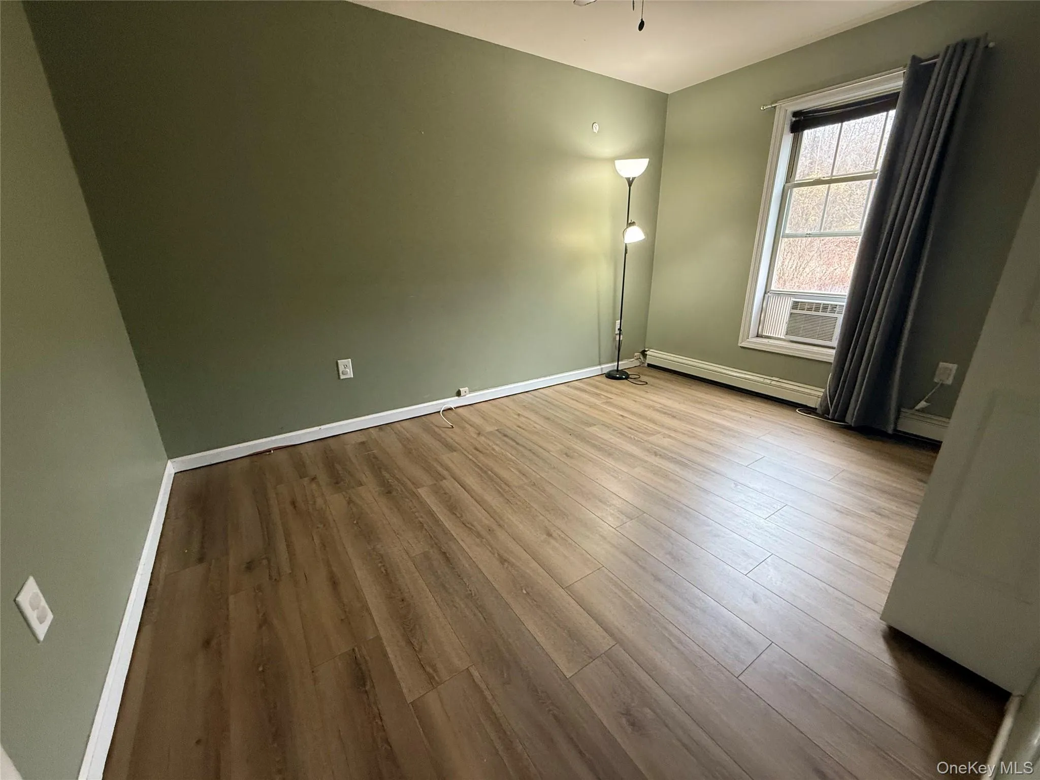 Spare room with wood finished floors and baseboards Spare room with wood finished floors and baseboards