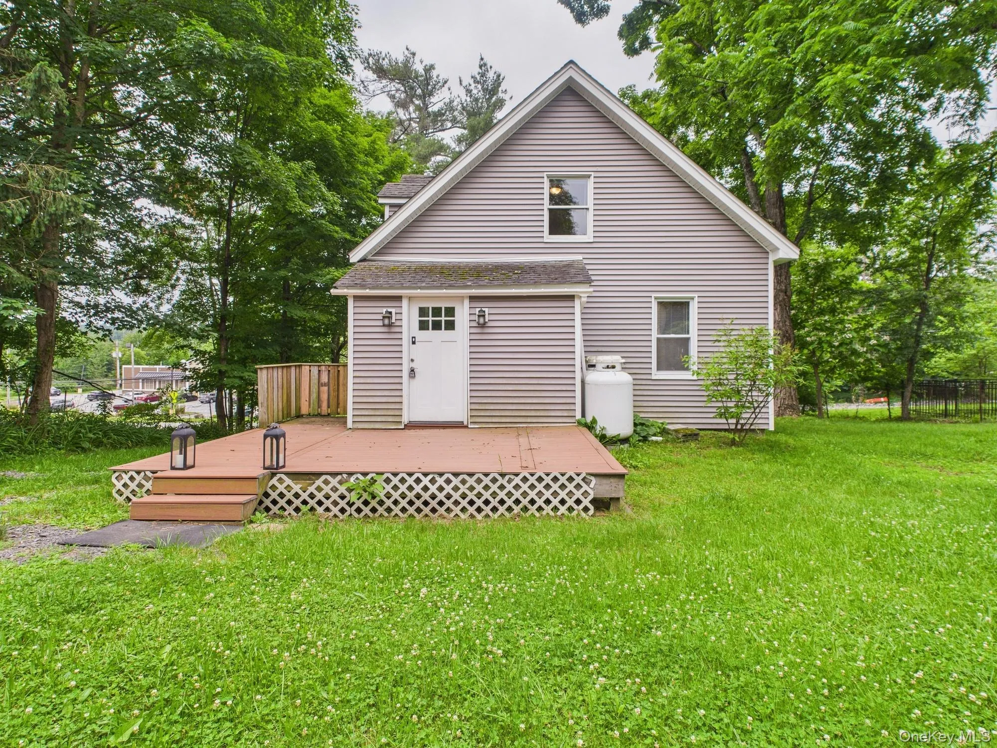 Back of property with a wooden deck and a shingled roof Back of property with a wooden deck and a shingled roof
