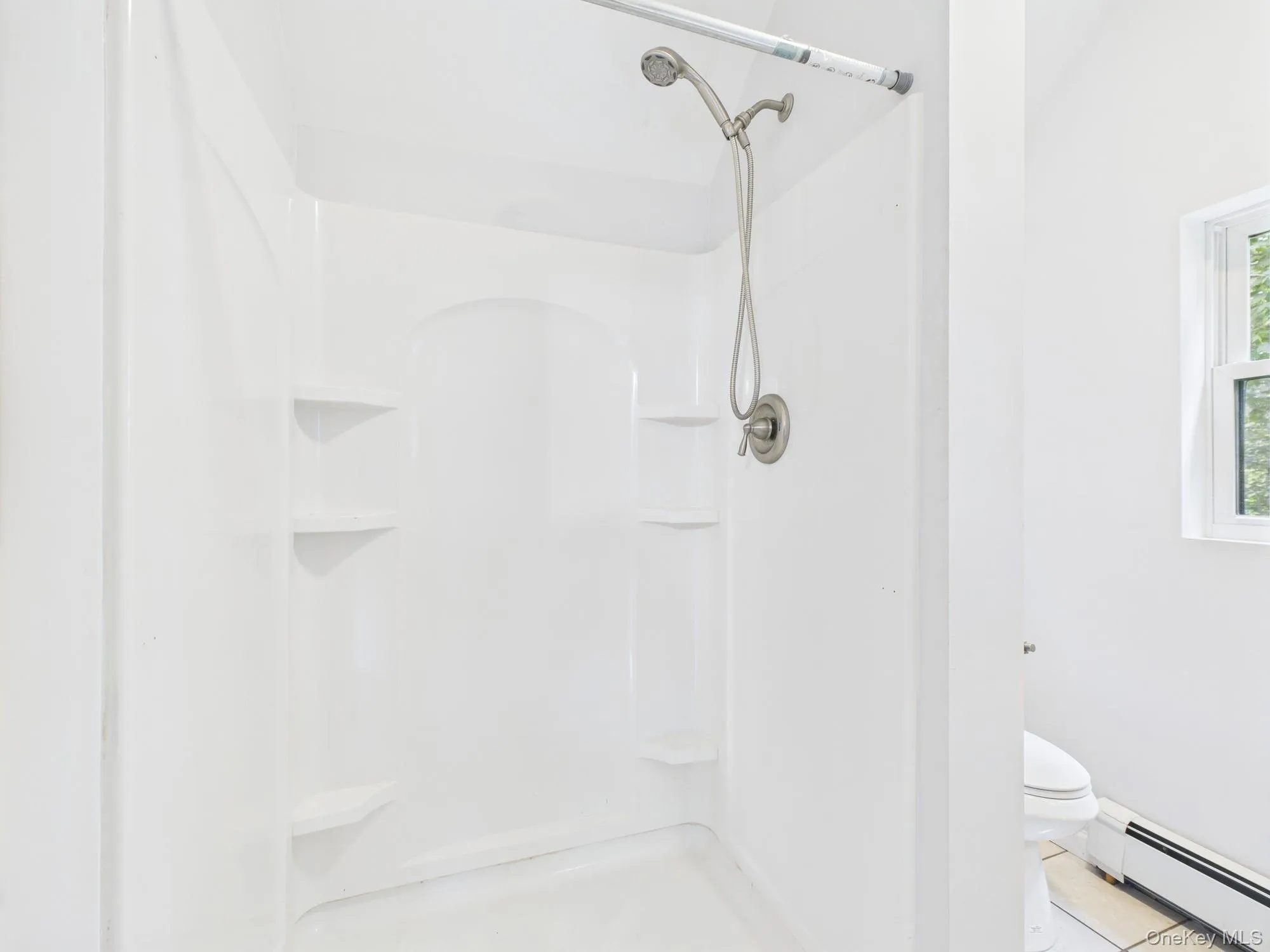 Full bathroom with a baseboard radiator, a shower, and tile patterned floors Full bathroom with a baseboard radiator, a shower, and tile patterned floors