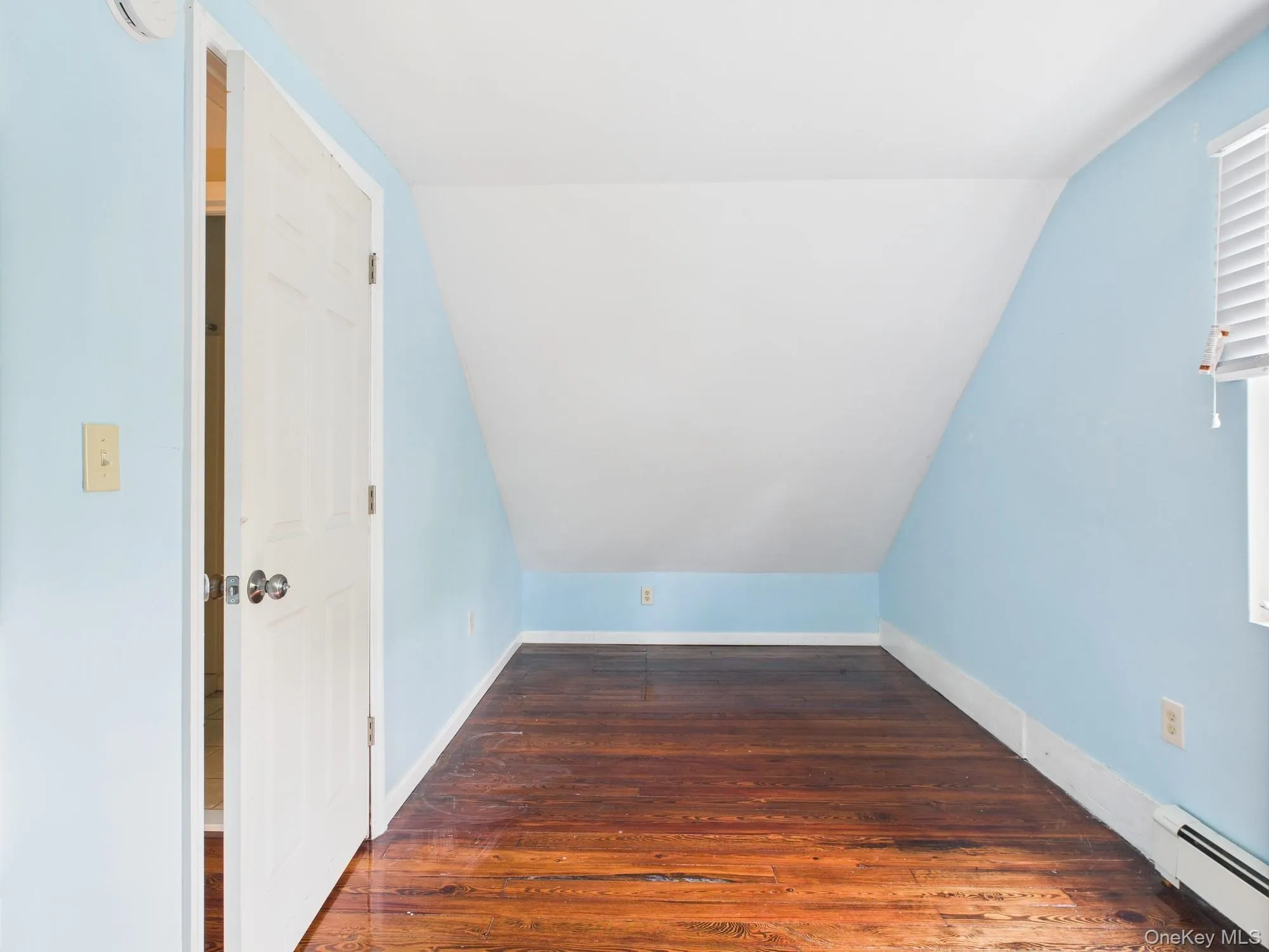 Bonus room with baseboard heating, lofted ceiling, and wood finished floors Bonus room with baseboard heating, lofted ceiling, and wood finished floors