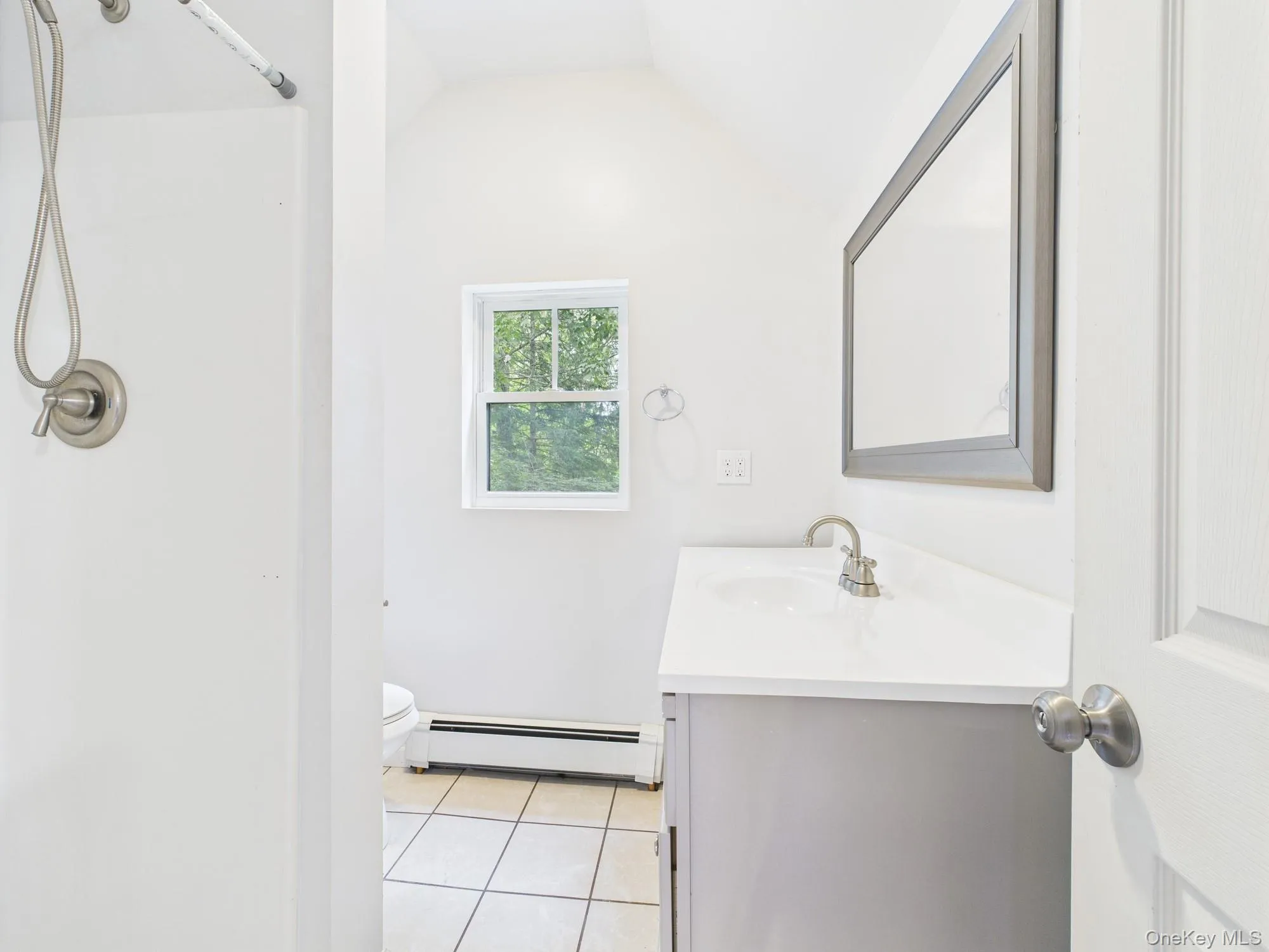 Full bathroom featuring a baseboard radiator, vanity, tile patterned floors, lofted ceiling, and a shower Full bathroom featuring a baseboard radiator, vanity, tile patterned floors, lofted ceiling, and a shower