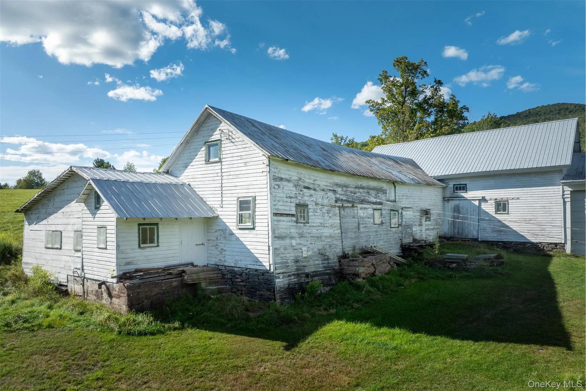 Rear view of house featuring a metal roof and a yard Rear view of house featuring a metal roof and a yard