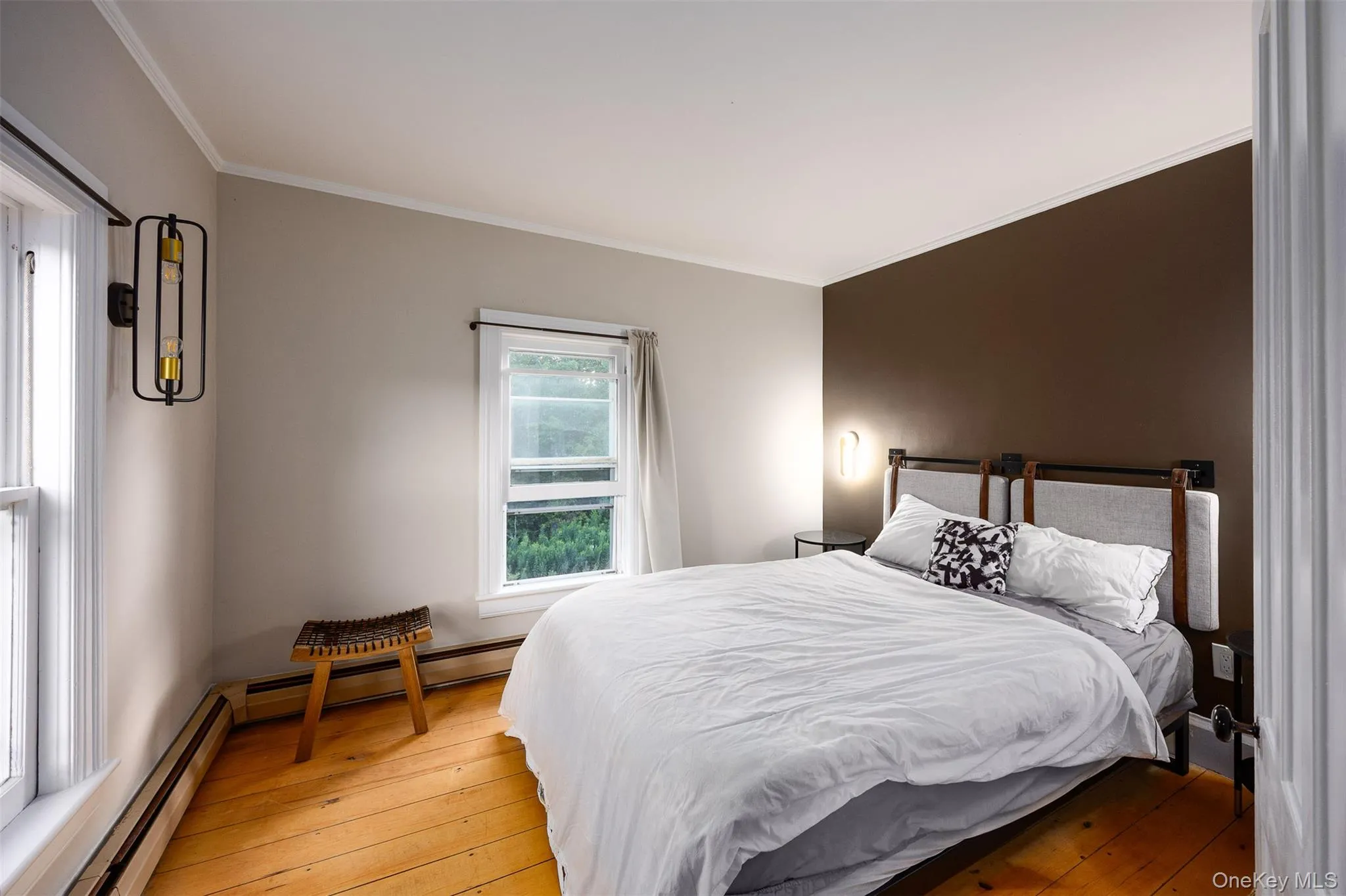 Bedroom with ornamental molding, hardwood / wood-style floors, and baseboard heating Bedroom with ornamental molding, hardwood / wood-style floors, and baseboard heating