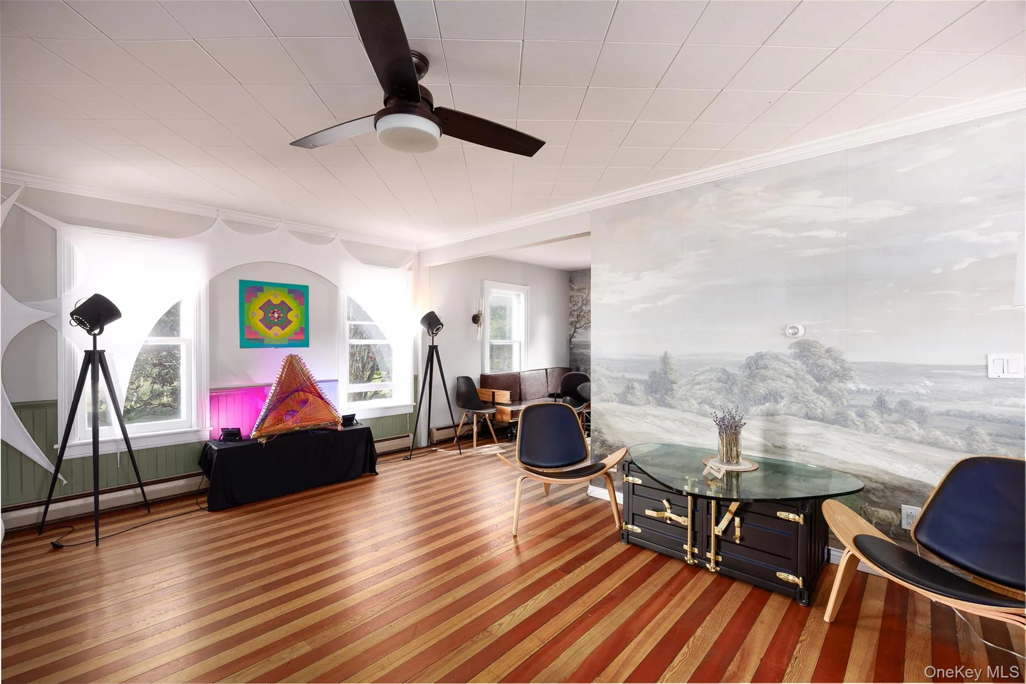 Sitting room with a ceiling fan, crown molding, wood finished floors, and a baseboard heating unit Sitting room with a ceiling fan, crown molding, wood finished floors, and a baseboard heating unit