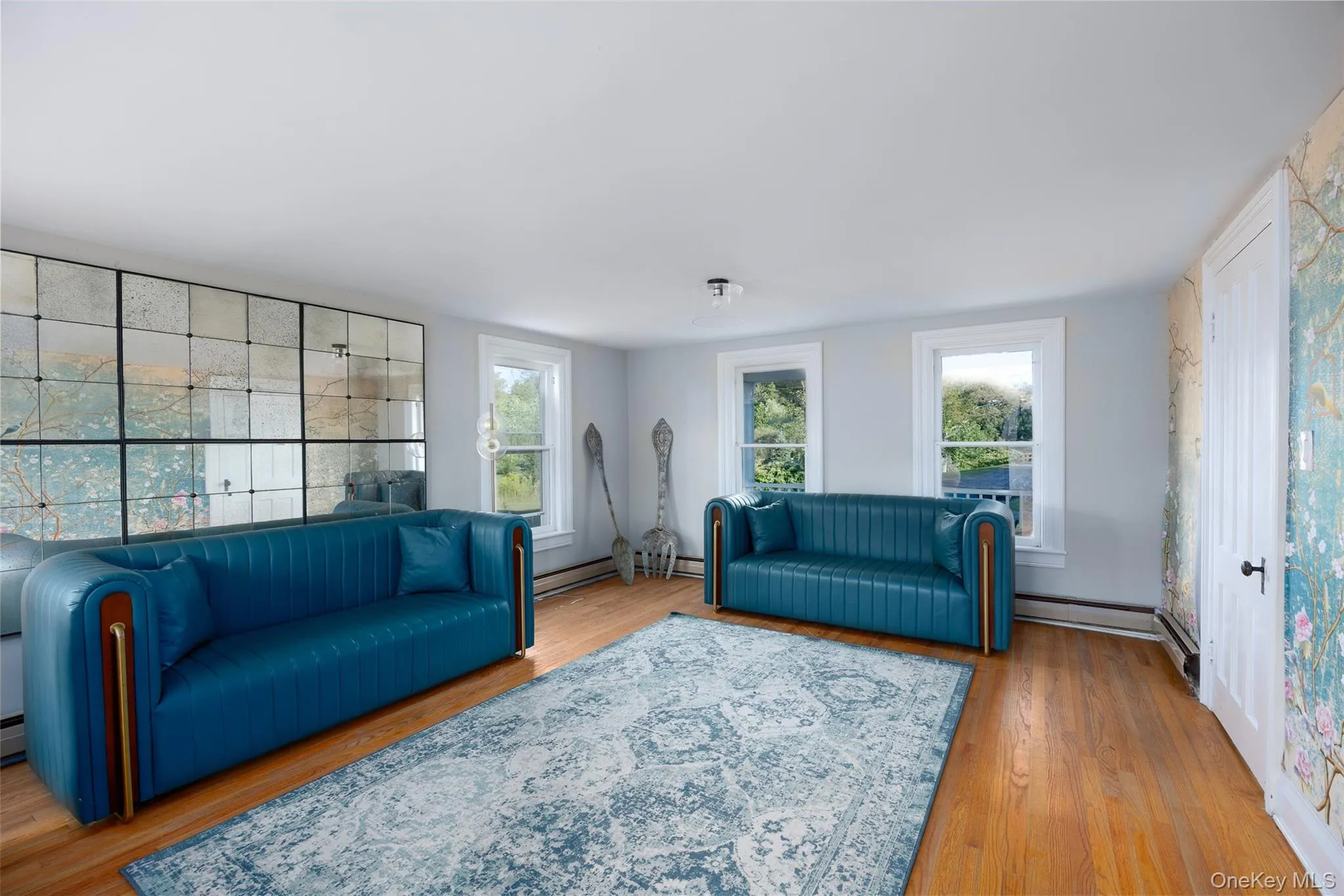 Living room featuring light wood-style flooring and a baseboard heating unit Living room featuring light wood-style flooring and a baseboard heating unit