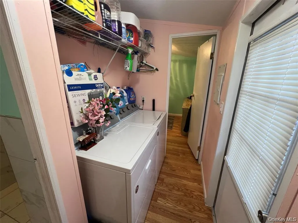 Laundry room with wood finished floors and washer and clothes dryer Laundry room with wood finished floors and washer and clothes dryer
