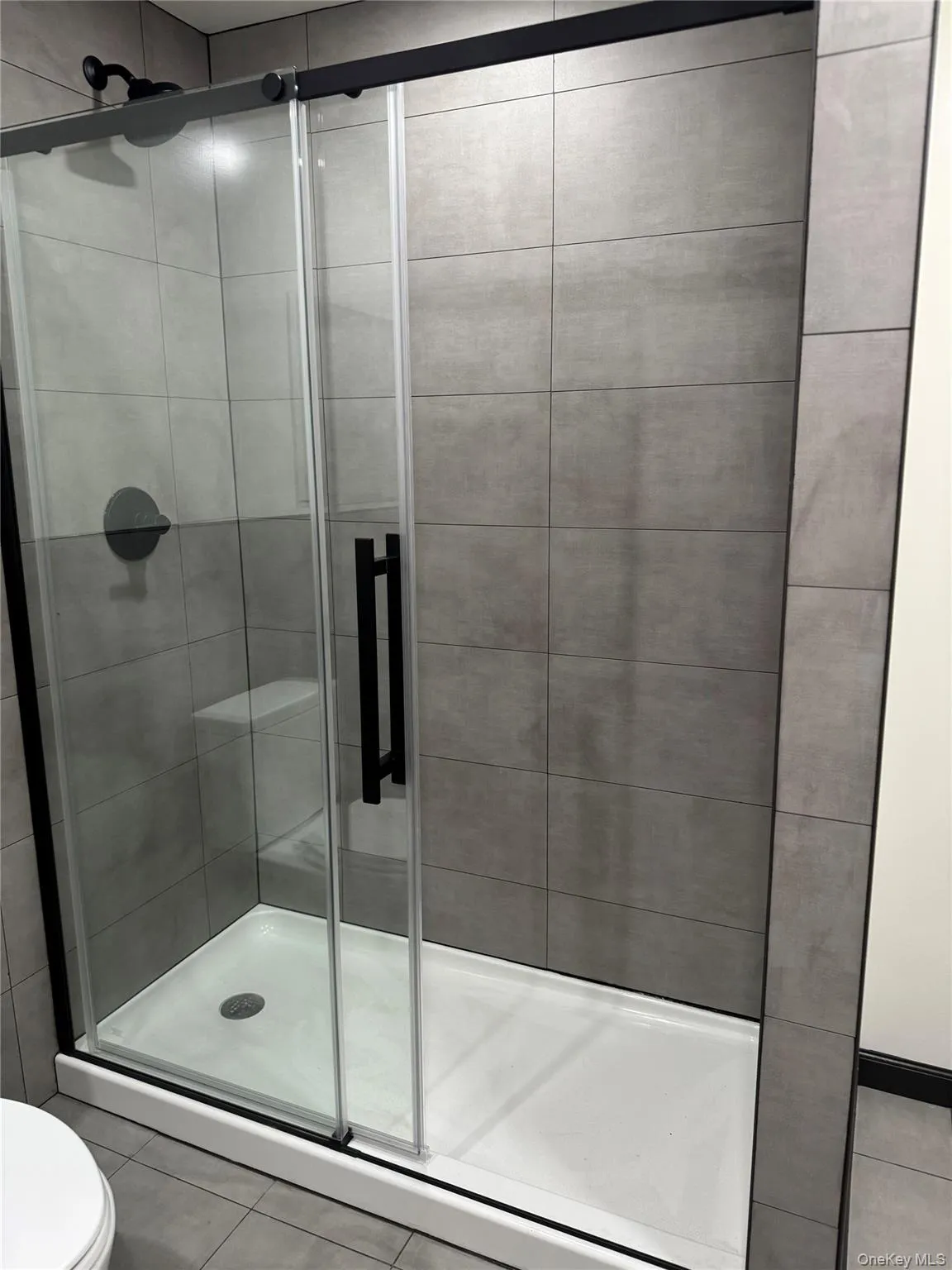 Bathroom featuring a shower stall and tile patterned floors Bathroom featuring a shower stall and tile patterned floors