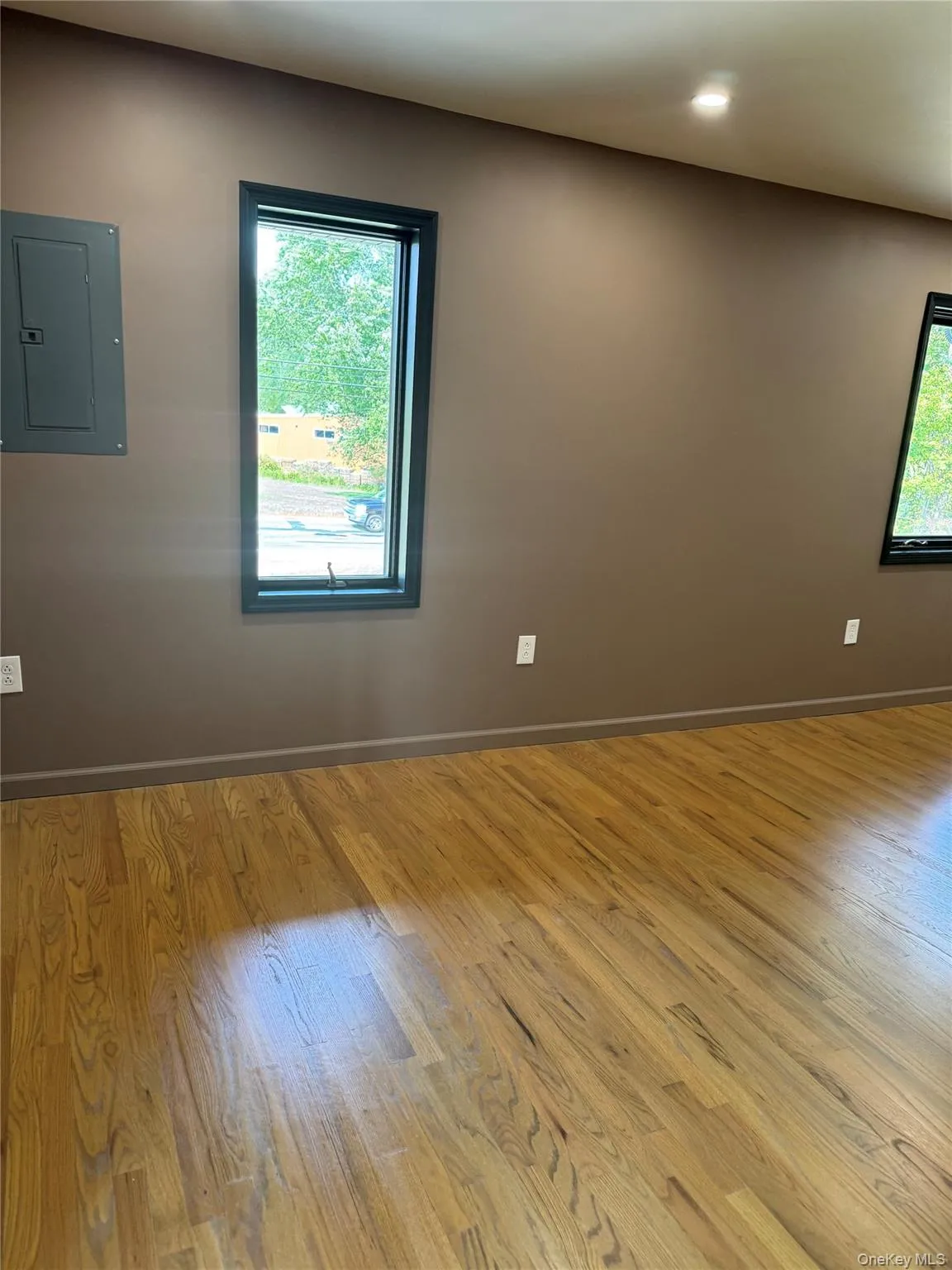 Unfurnished room with electric panel, wood finished floors, and recessed lighting Unfurnished room with electric panel, wood finished floors, and recessed lighting