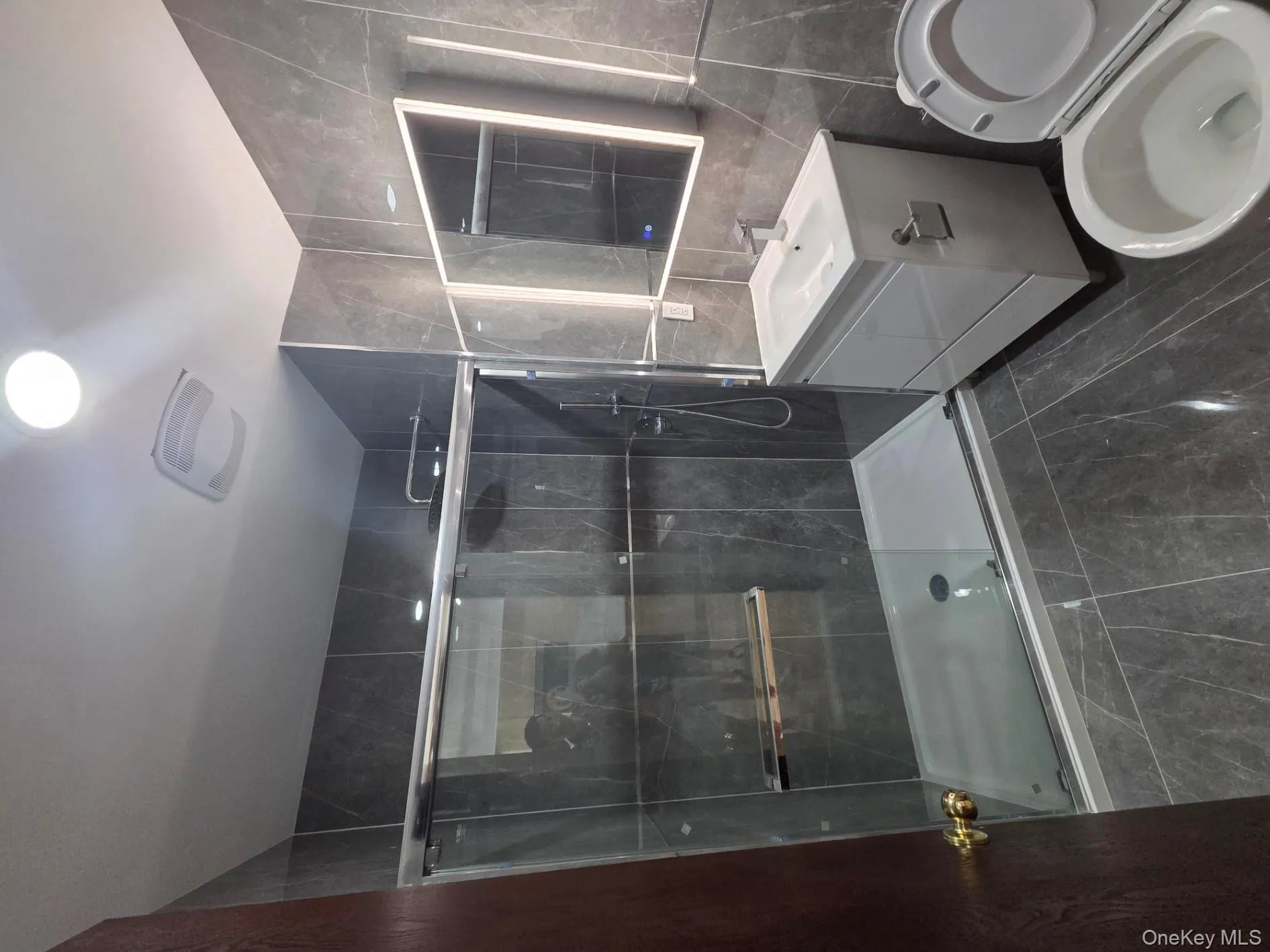 Full bath featuring tile walls, vanity, and a stall shower Full bath featuring tile walls, vanity, and a stall shower