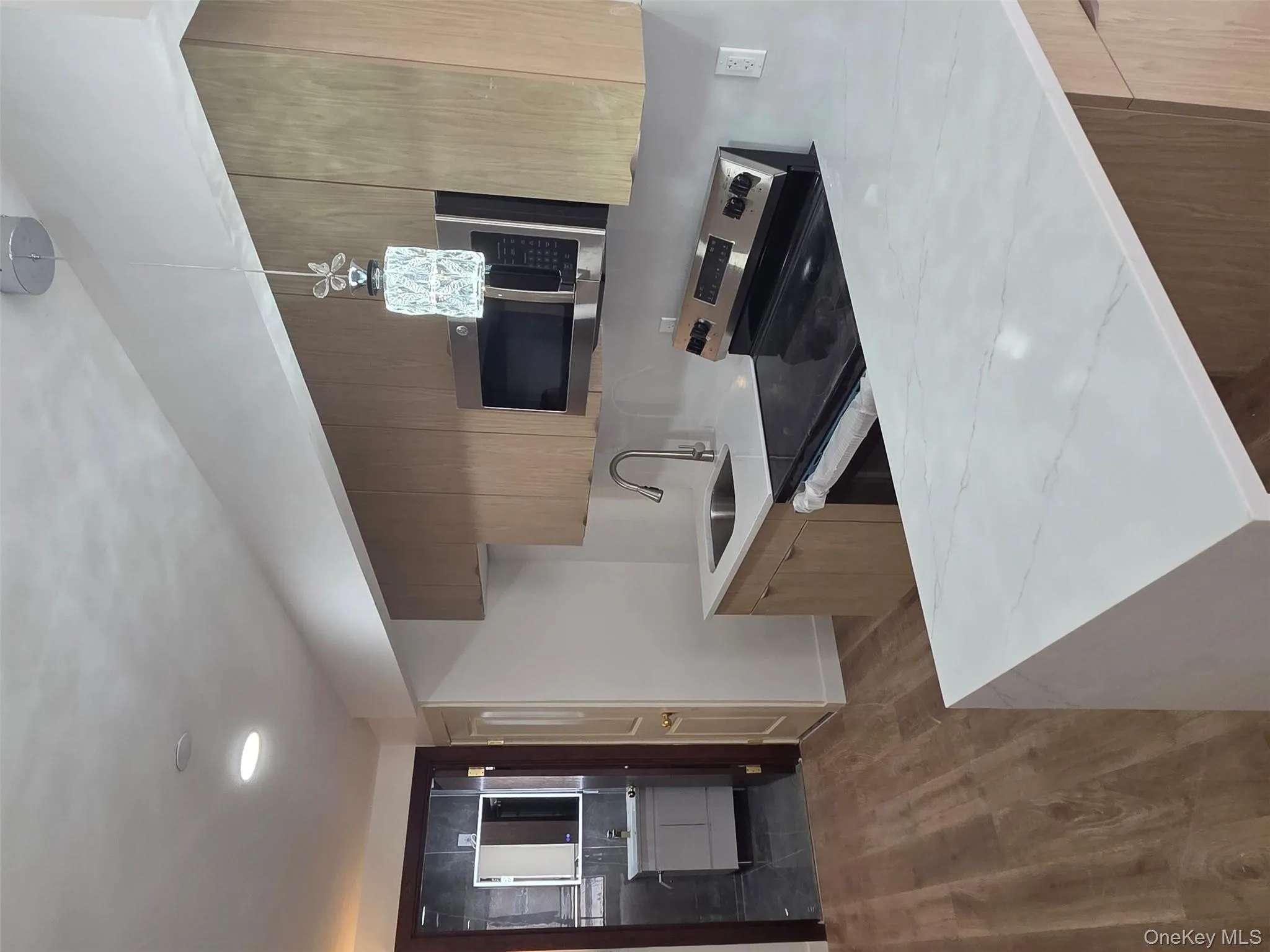 Kitchen featuring white range oven, light stone counters, stainless steel microwave, modern cabinets, and dark wood-type flooring Kitchen featuring white range oven, light stone counters, stainless steel microwave, modern cabinets, and dark wood-type flooring